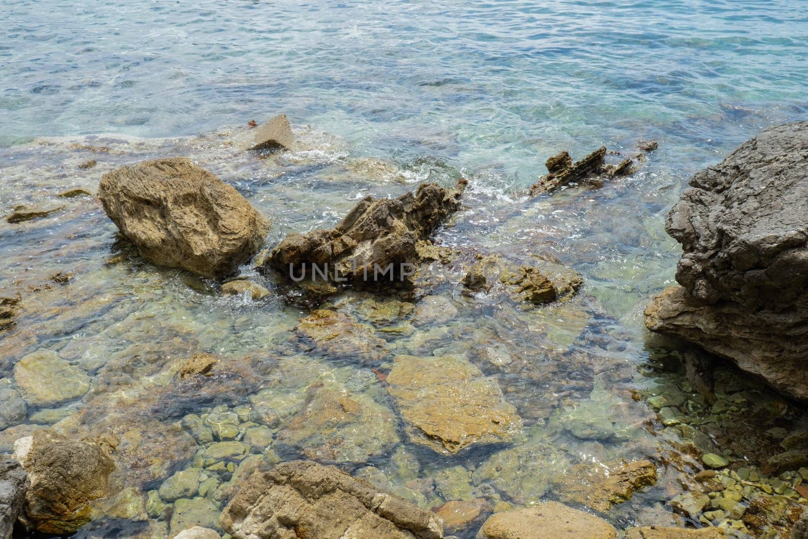 Beautiful rocks and bright turquoise water among layered rocks near Budva, Montenegro. Tropical summer landscape exotic beach on the Adriatic Sea. Vacation holiday idea