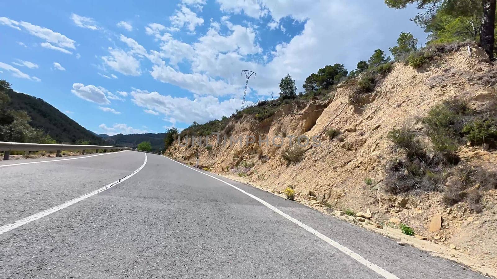 A beautiful highway winds through majestic mountains, showcasing natures beauty and clear blue skies