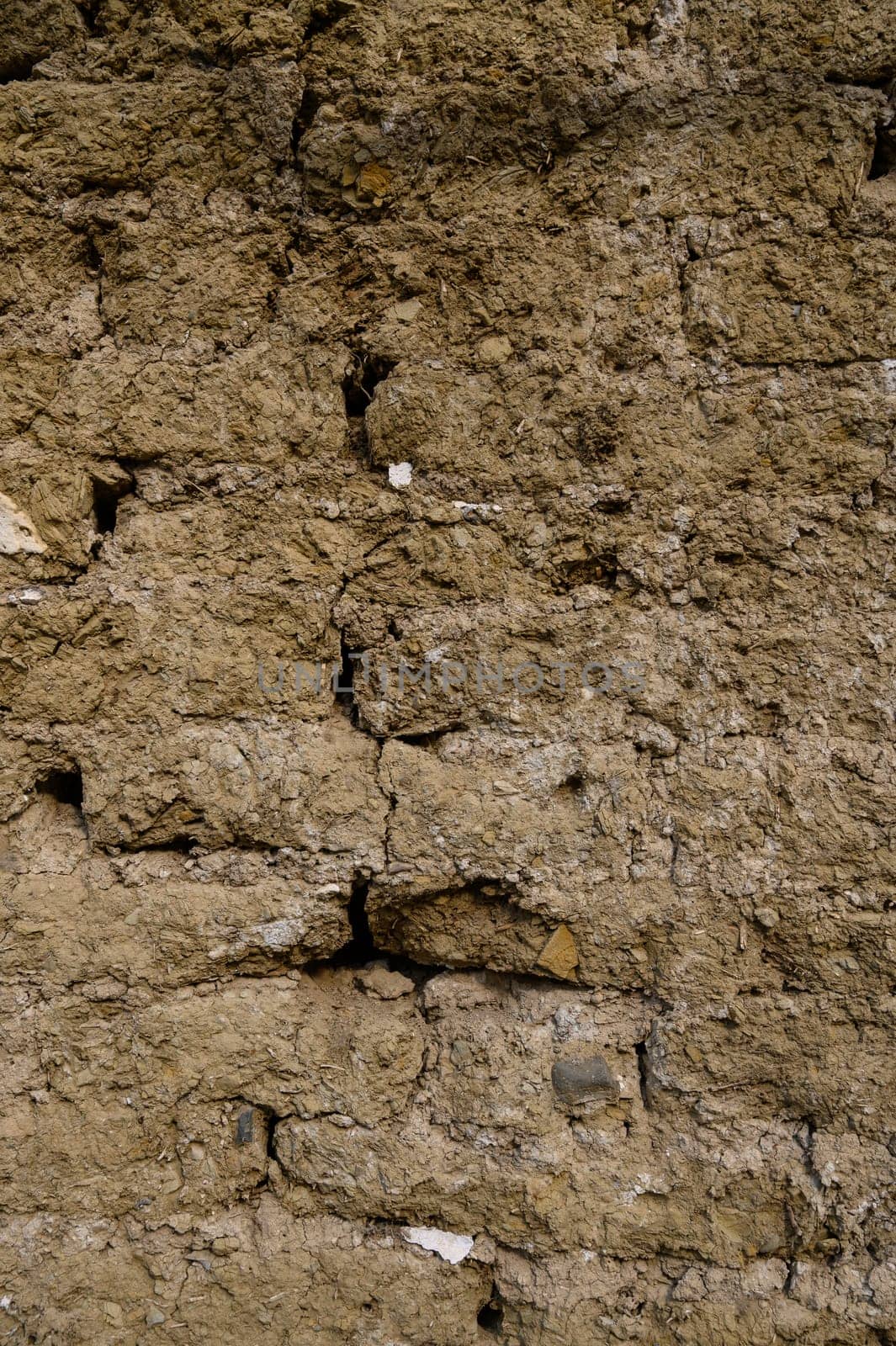 Rough and aged concrete wall surface with cracks and stains. Perfect for use as a textured background or design element.