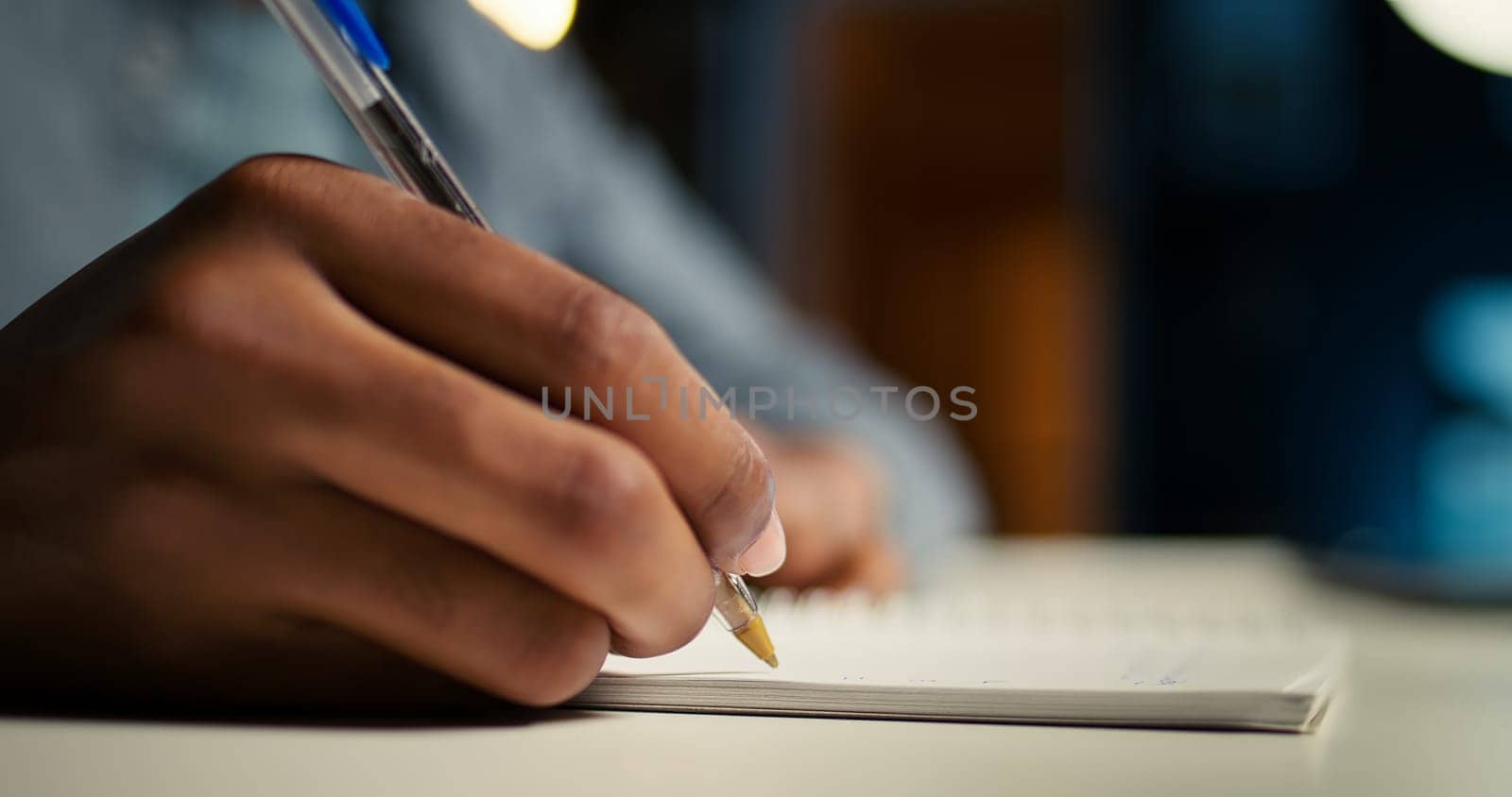 African American person working remotely and drafting project notes, organizing files and browsing web for relevant information. Comfortable home office setup for telework productivity. Camera A.