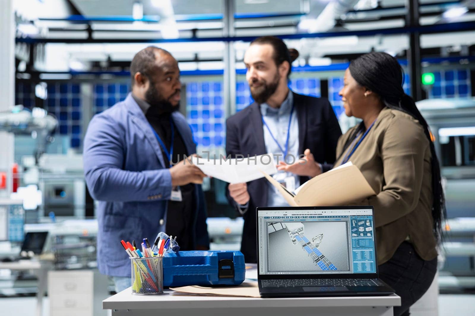 Diverse master engineers group examining solar panels production line in a plant, ensuring a good manufacturing process and production with teamwork. Industrial renewable energy.
