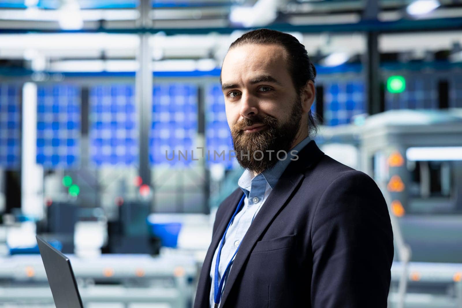 Factory inspector in a suit monitoring solar panel production output, reflecting professional occupation and executive level involvement in renewable energy development. Solar power.