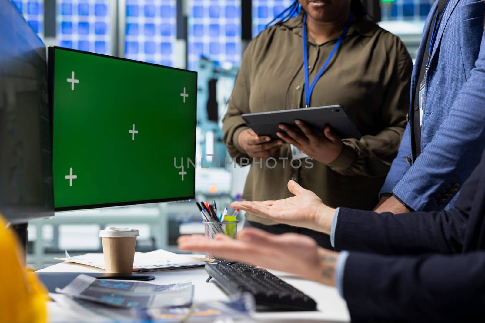Coworkers brainstorming solutions with mockup display in solar plant, advancing industrial goals through collaboration and corporate responsibility. Team of engineers share insight.