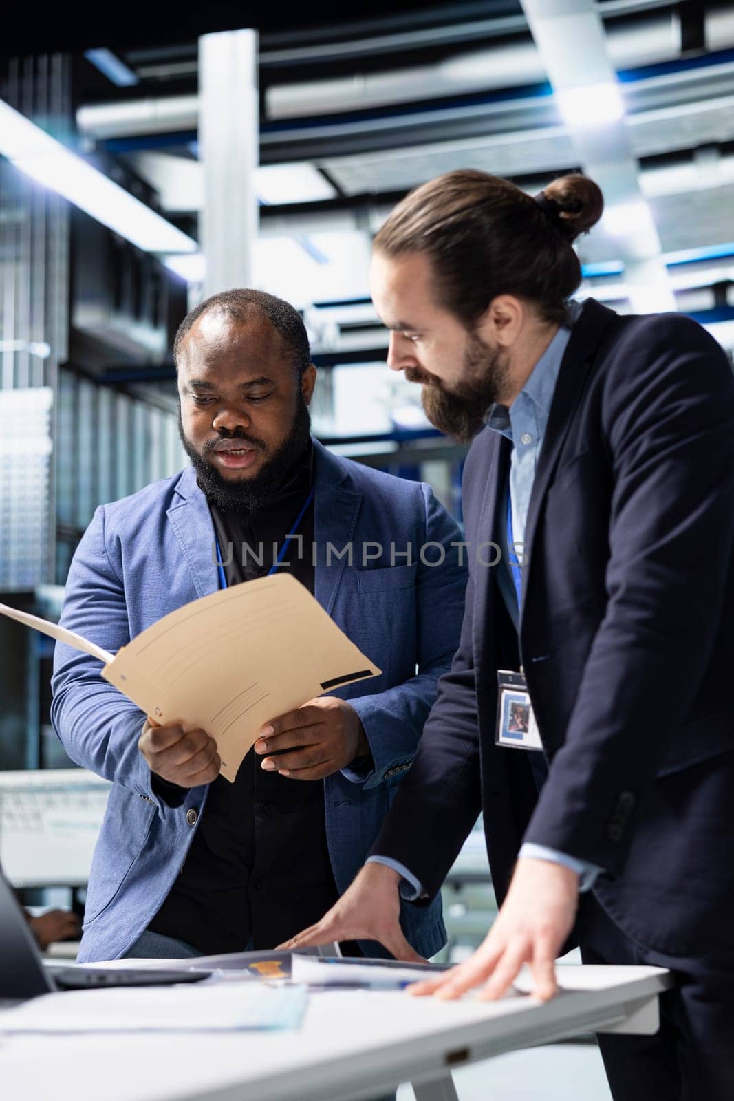 Team of diverse engineers business partners evaluates solar performance in a modern industrial factory, focusing on sustainable development. Renewable power for sustainability.