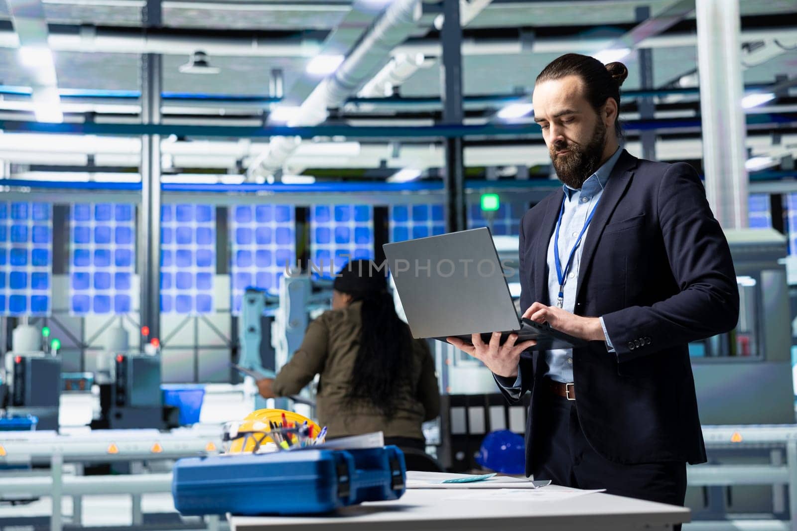 Engineer consultant in formal attire evaluates factory workflow, combining business expertise and industrial efficiency in solar tech manufacturing industry. Clean energy and innovation.