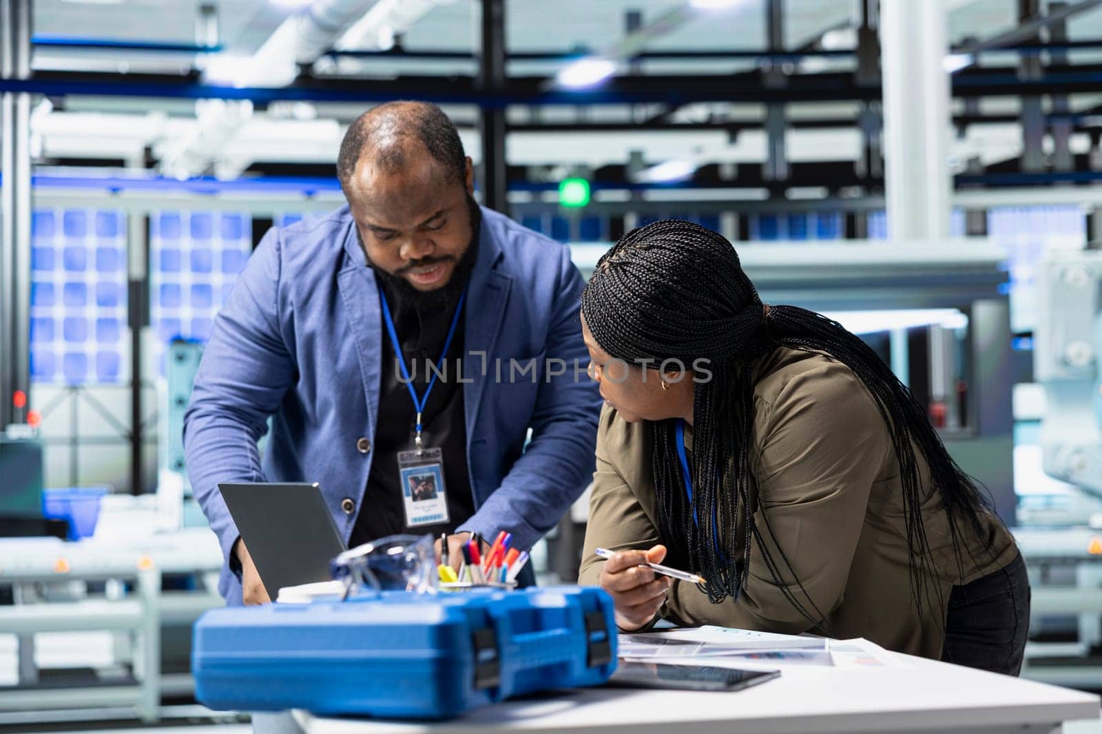 Black industry engineers team working together on solar panel systems during a production inspection, ensuring engineering accuracy, quality control and factory operations efficiency.