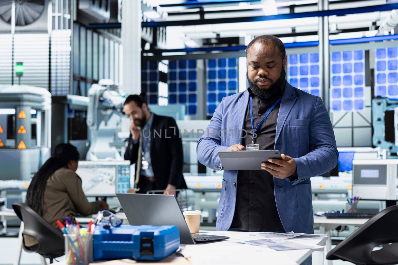African american supervisor checking solar panel machinery and reviewing a checklist, playing a vital role in renewable energy production and assembly line. Efficient solar tech infrastructure.