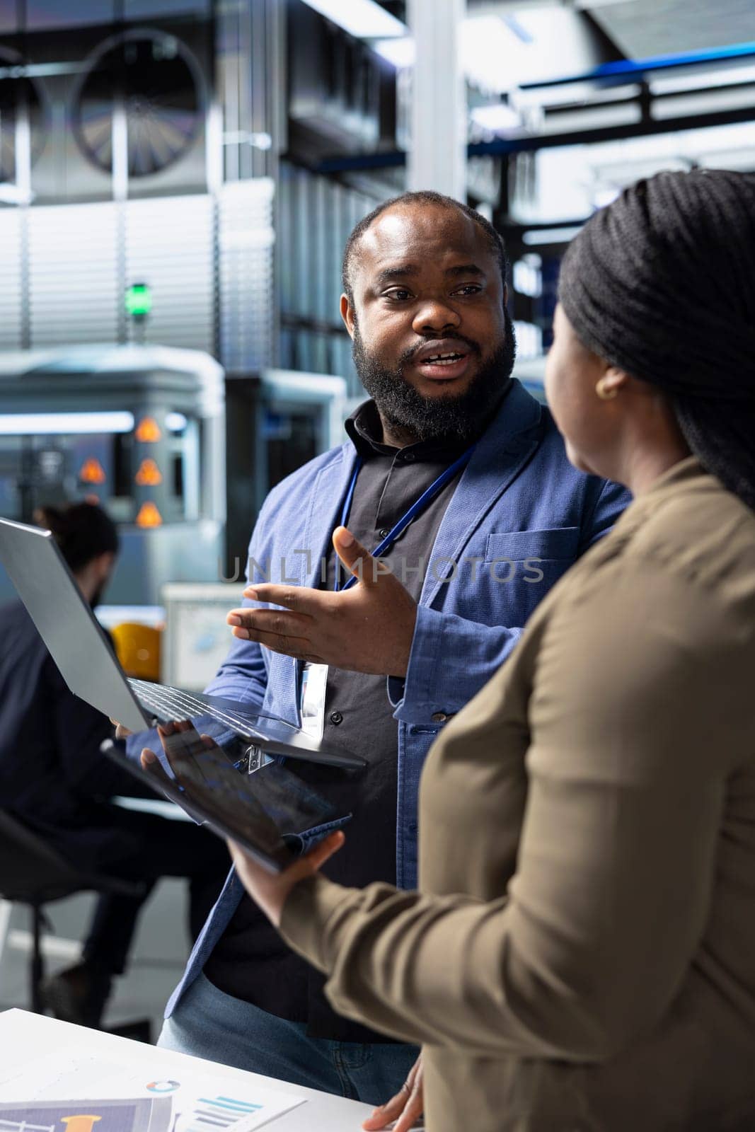 African american team of energy consultants analyzing insight in solar panel plant, ensuring high standards in renewable energy production line, quality control and manufacturing efficiency.