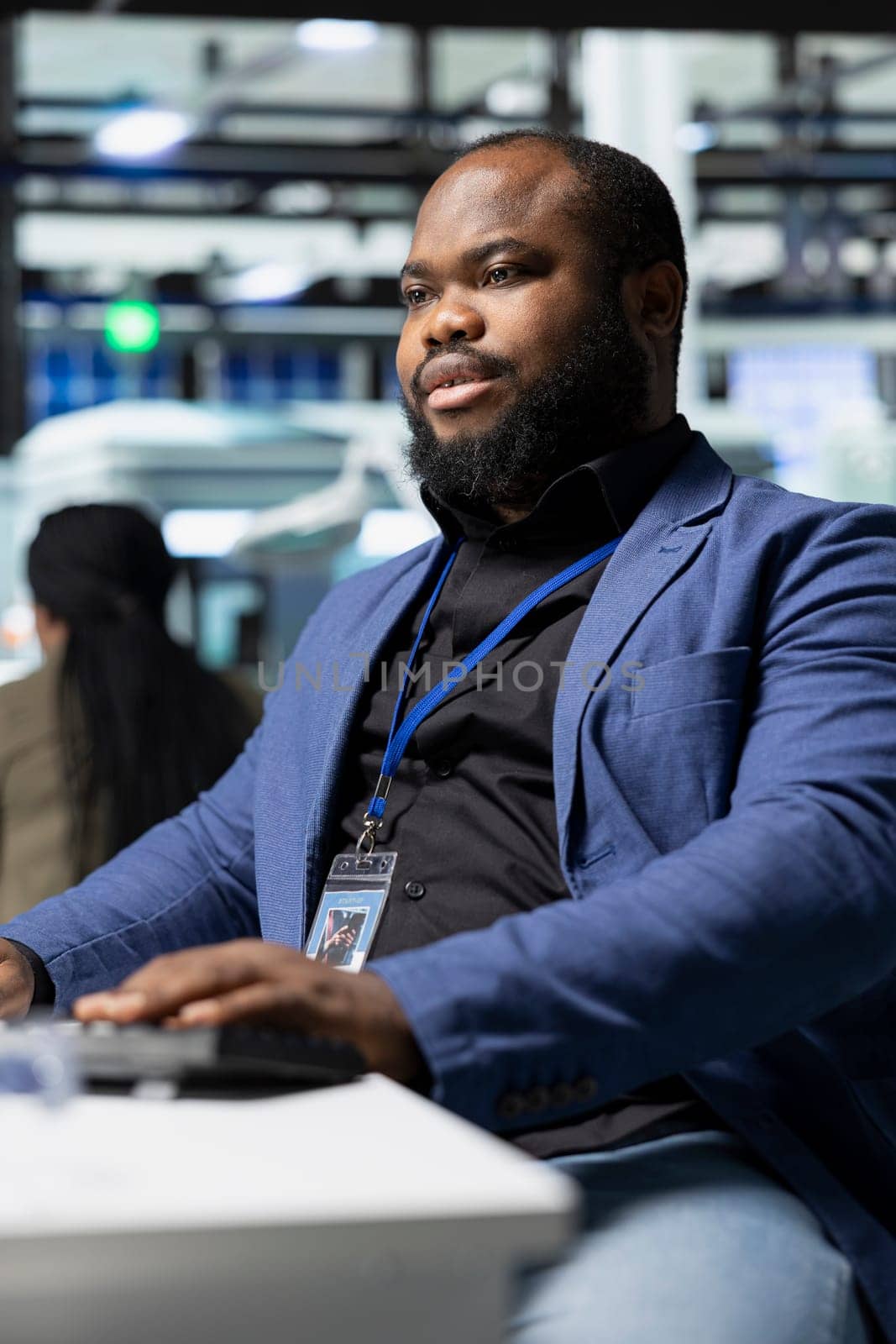 African american male supervisor observes production systems on a pc in a solar plant, providing expert feedback on efficiency, safety and sustainability aligned with green energy initiatives.
