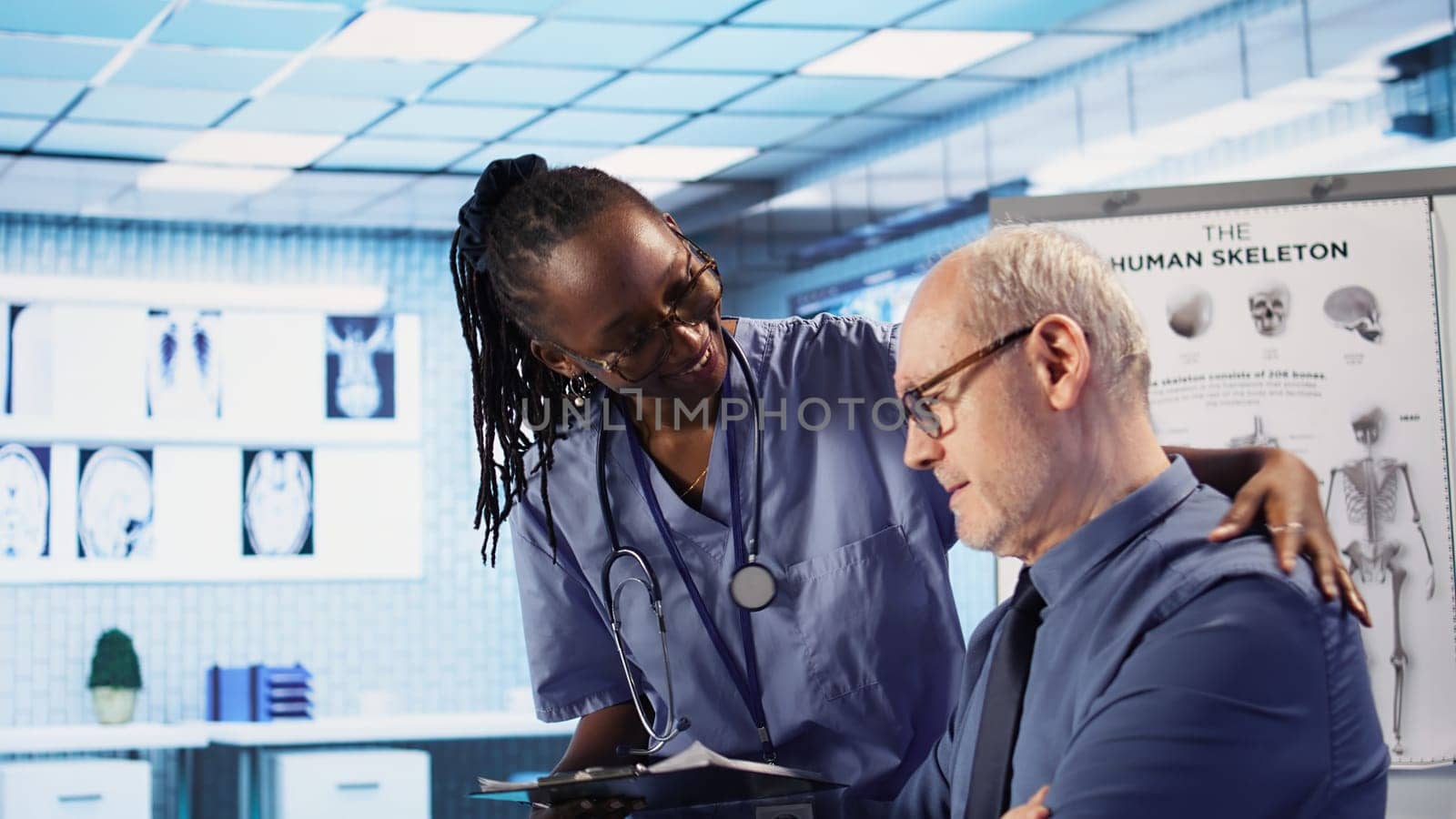 Expert and african american assistant provide medical services to patient at checkup, giving diagnostics report and medical records. Medical staff ensure healthcare exam on insurance. Camera A.