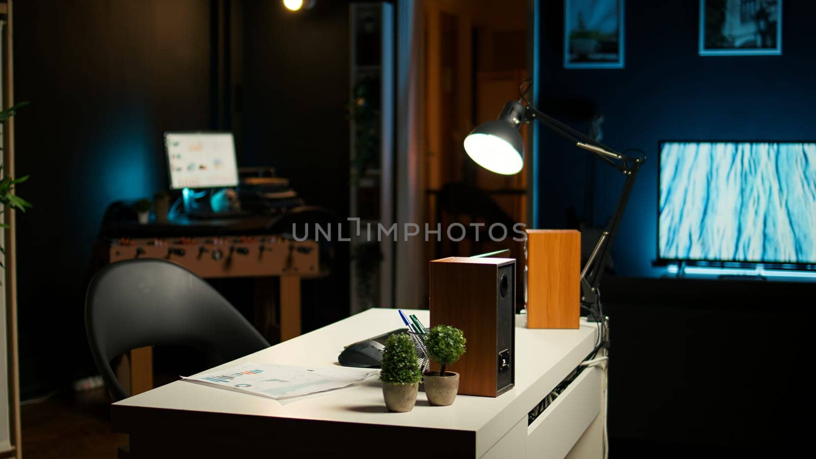Stylish home office in a modern loft apartment with cozy creative workspace with wooden furniture, house plants and a TV in a spacious living room. Perfect for a comfortable, urban lifestyle.