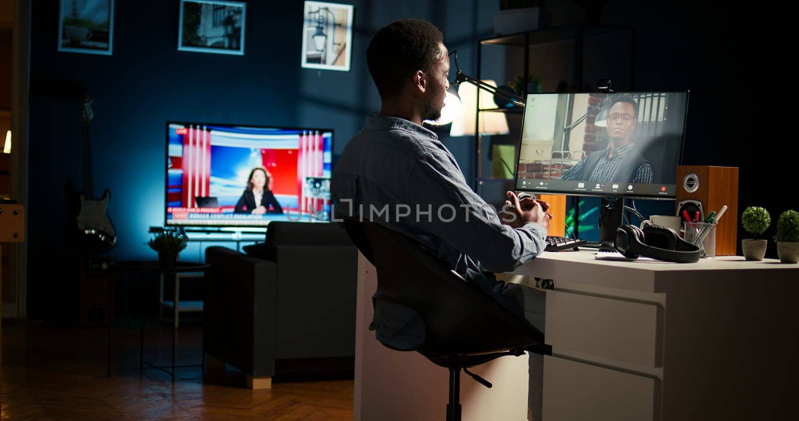 African American young guy meeting with his boss to discuss task completion, enjoying remote job from the comfort of his modern loft. Waving on a video call online, briefing session. Camera A.