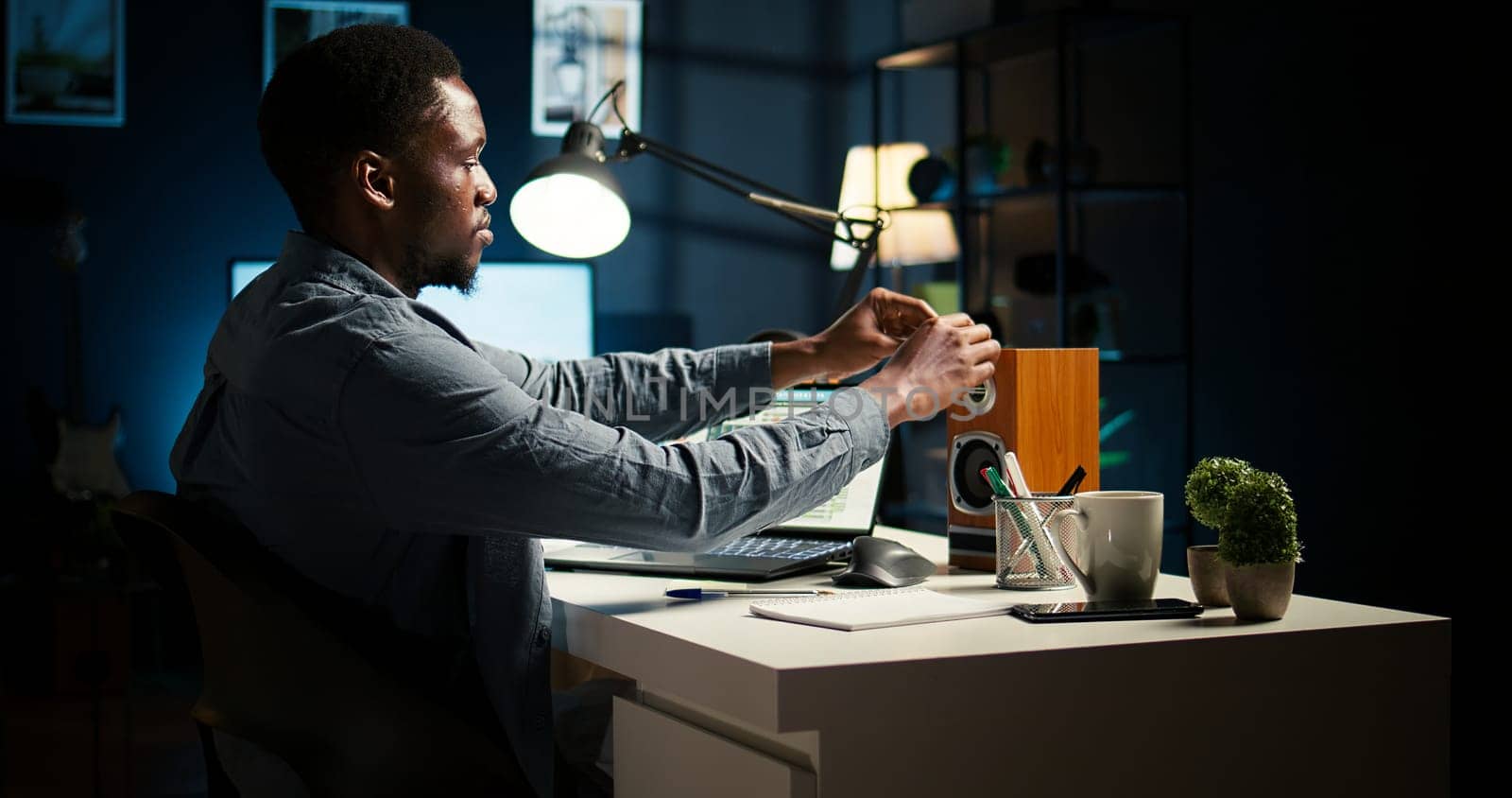 Independent freelancer creates a post it reminder and reviews project data, doing handwritten notes and placing sticky notes to remember his remote tasks. Researching articles. Camera A.