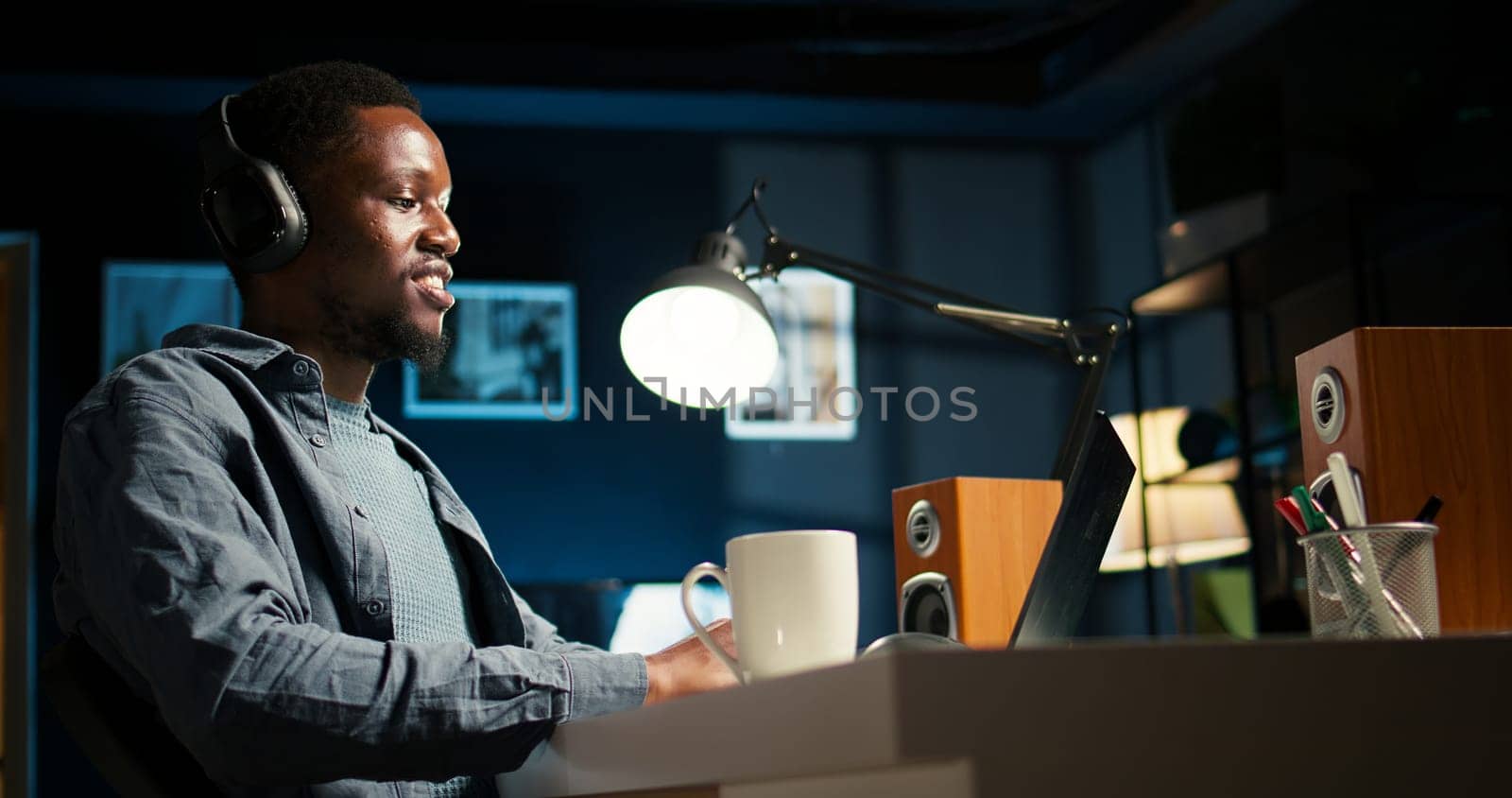 African american guy does remote work and engaging in a web conversation, using his laptop to attend an online video call meeting in his living room. Young man joining a conference. Camera A.