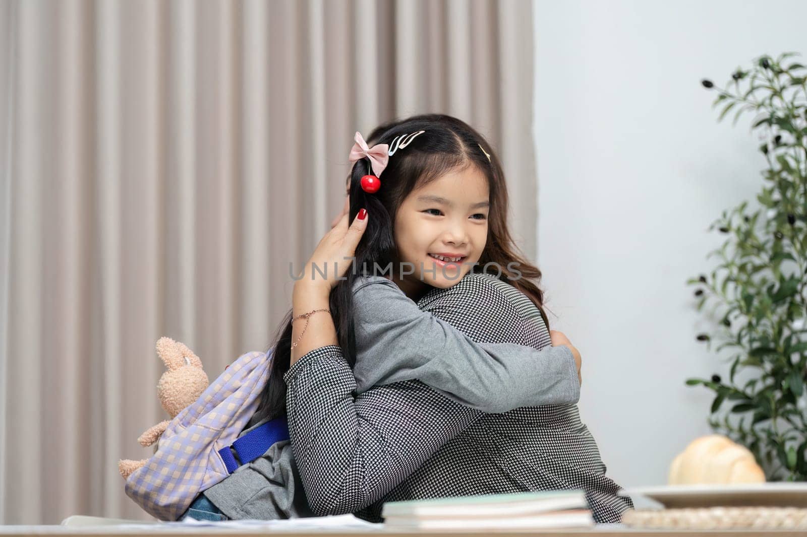 A heartwarming moment as a young girl embraces her mother, showcasing the love and connection they share in their home environment.