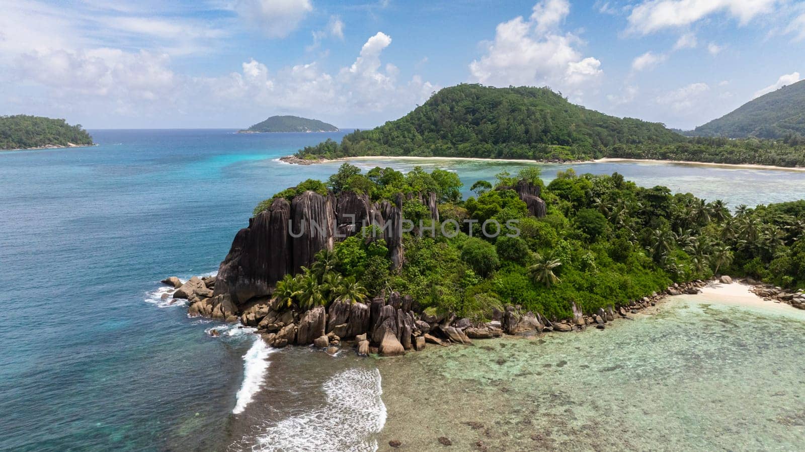 Sandy beaches, granite boulders, lush vegetation and hills on a tropical island. Seychelles, Mahe.