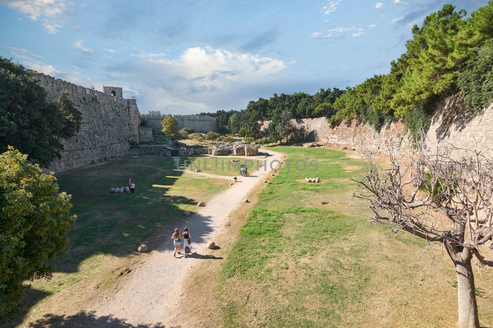 Rodas.Greece - june 04, 2025: Tranquil pathway winding through the ancient moats of Rhodes, offering a glimpse into the city's rich past.