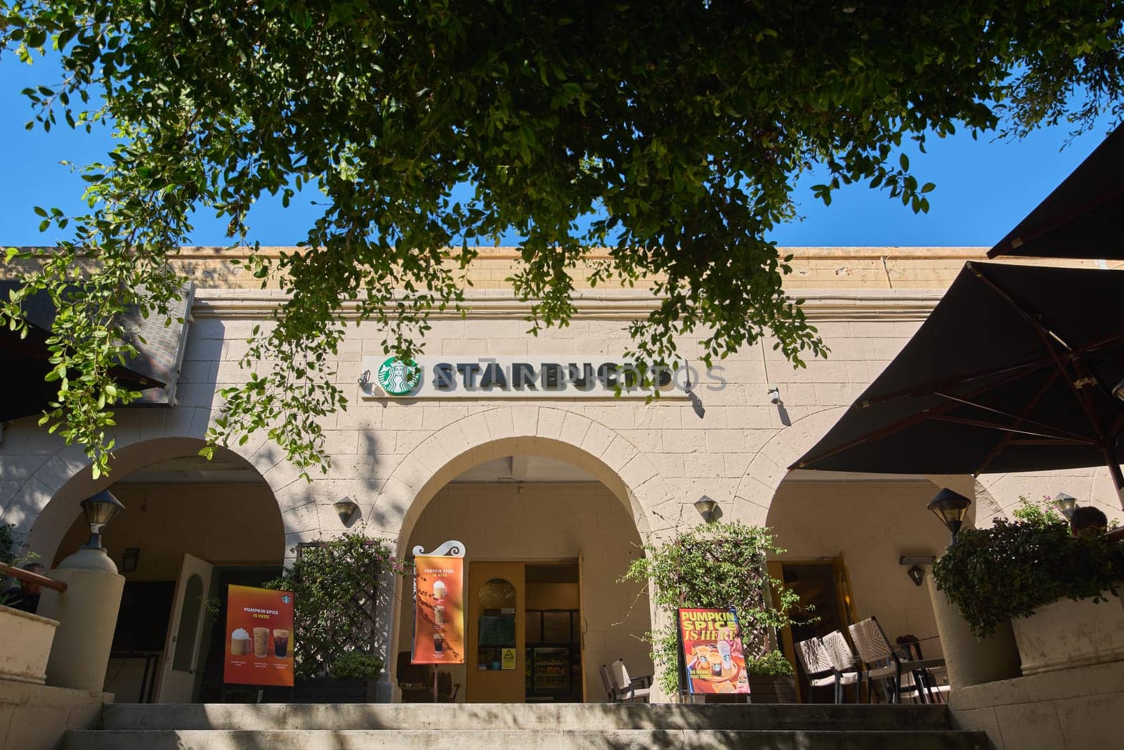Rodas.Greece - june 04, 2025:  Exterior of a Starbucks coffee shop in Rhodes, featuring its iconic logo and architectural details under a clear blue sky.