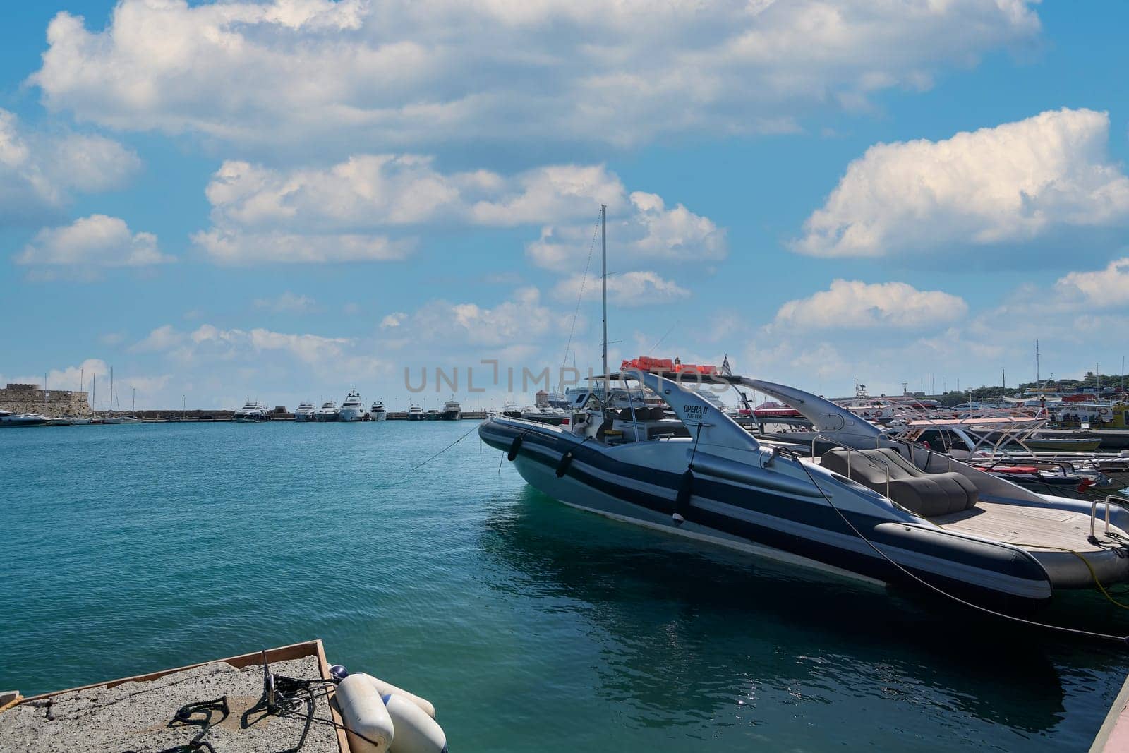 Rodas.Greece - june 04, 2025: Wide angle view of the lively Rhodes harbor, showcasing diverse maritime vessels and the beauty of the Aegean Sea.