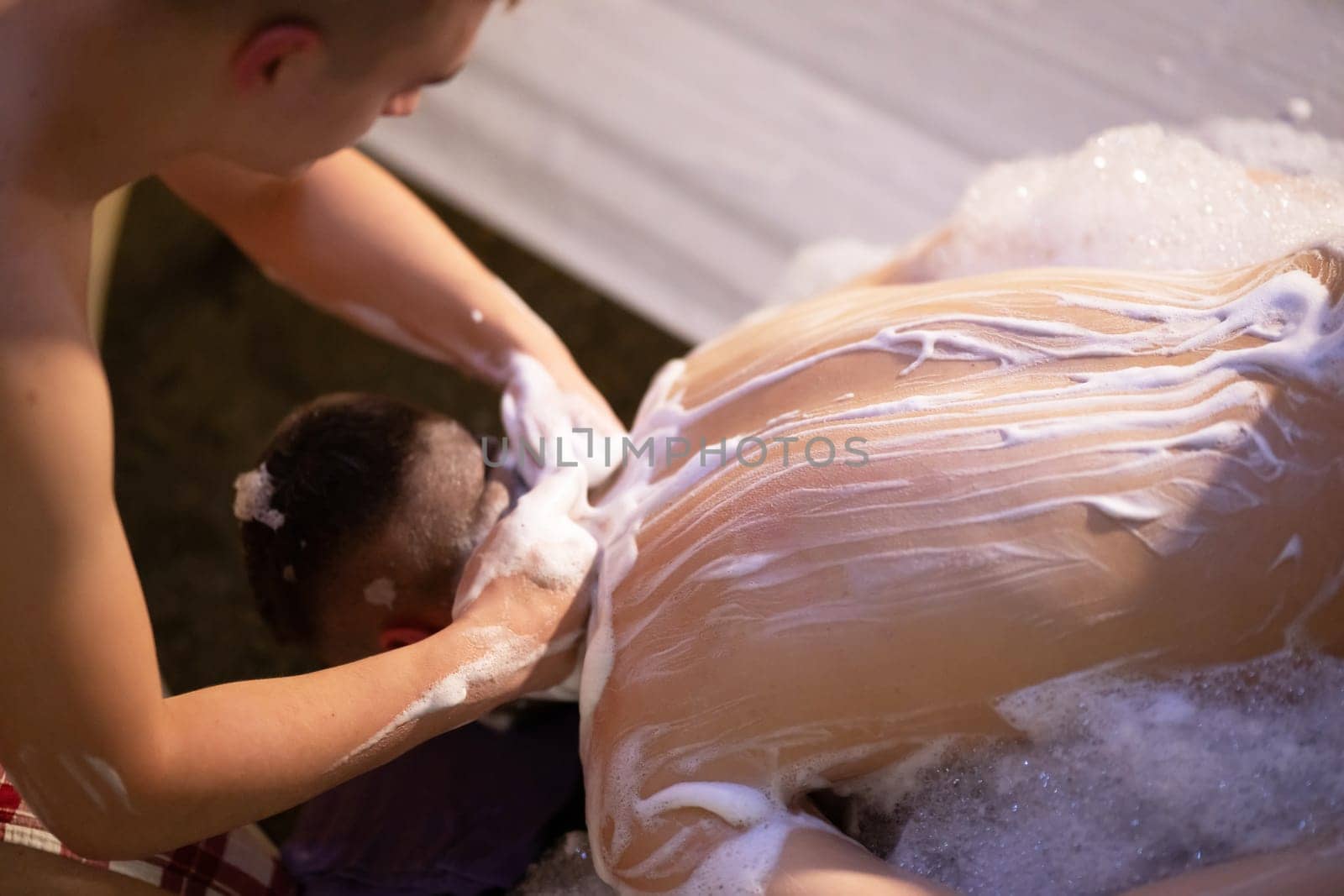 Back Massage with Foam. Therapist applies soap foam with htheir ands on patients back during traditional bath ritual