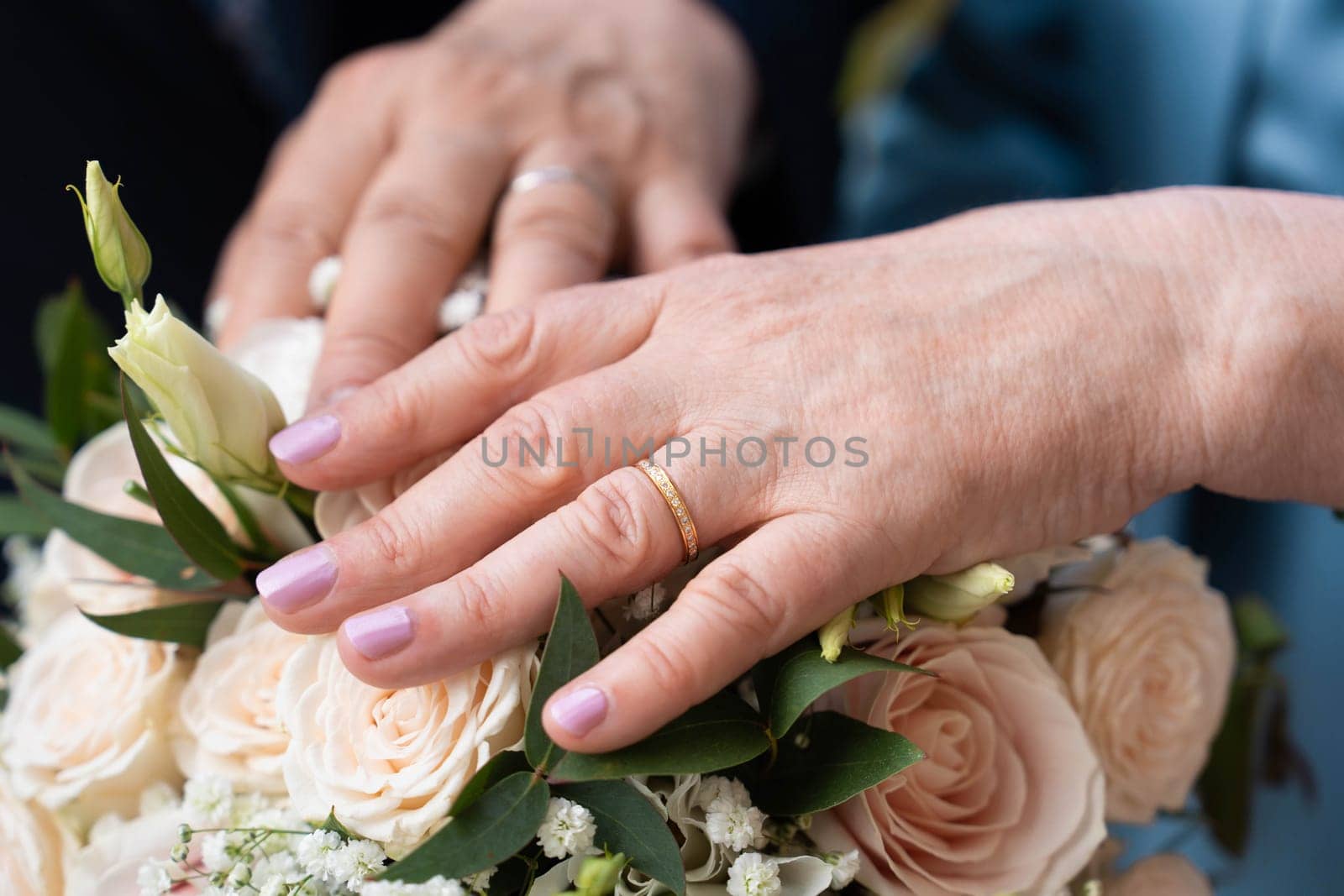 Married elderly couple holding hands with rings wedding day