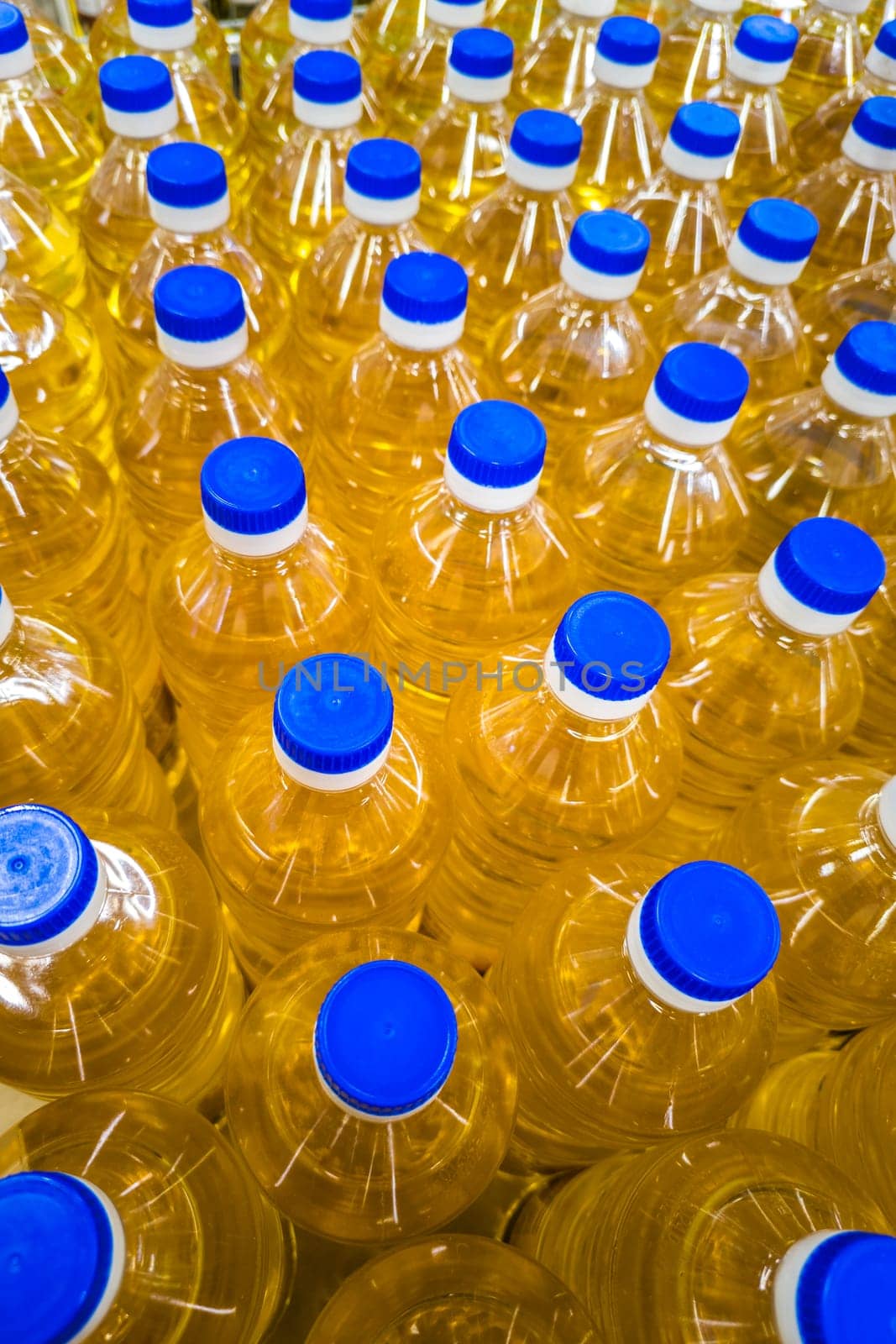stack of bottles with sunflower seed oil at the grocery store, full-frame closeup view