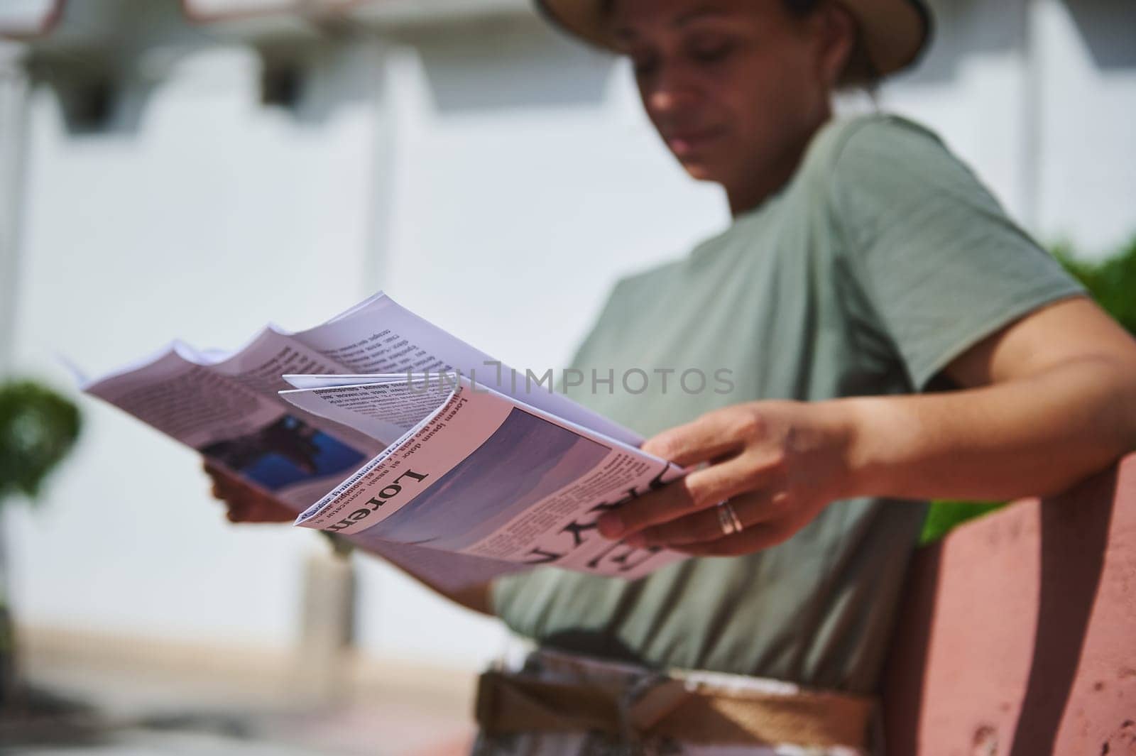 Outdoor setting with a woman enjoying reading a magazine. Relaxed atmosphere under bright daylight conditions, capturing a simple moment of leisure and focus on reading.