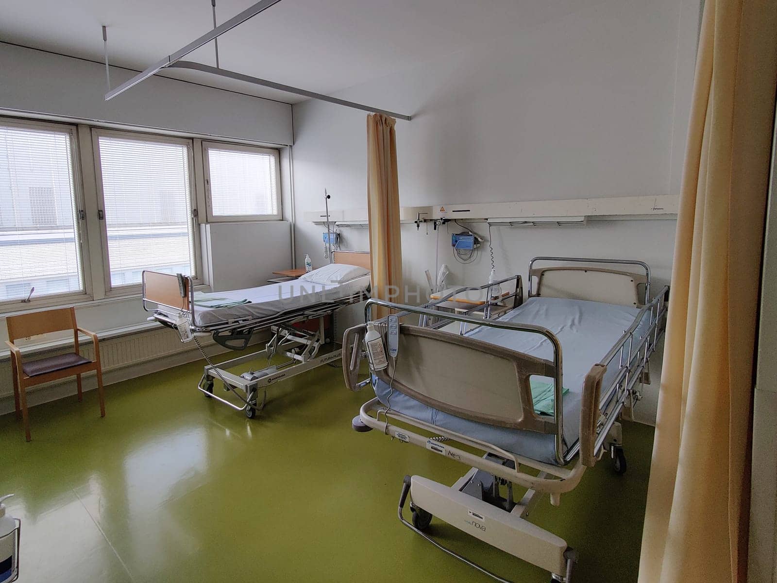 Espoo, Finland - April 14, 2025: hospital room at Jorvi Hospital or Jorvinsairaala, hospital beds with side rails, medical equipment, and a bedside table, typical modern Finnish public healthcare facilities