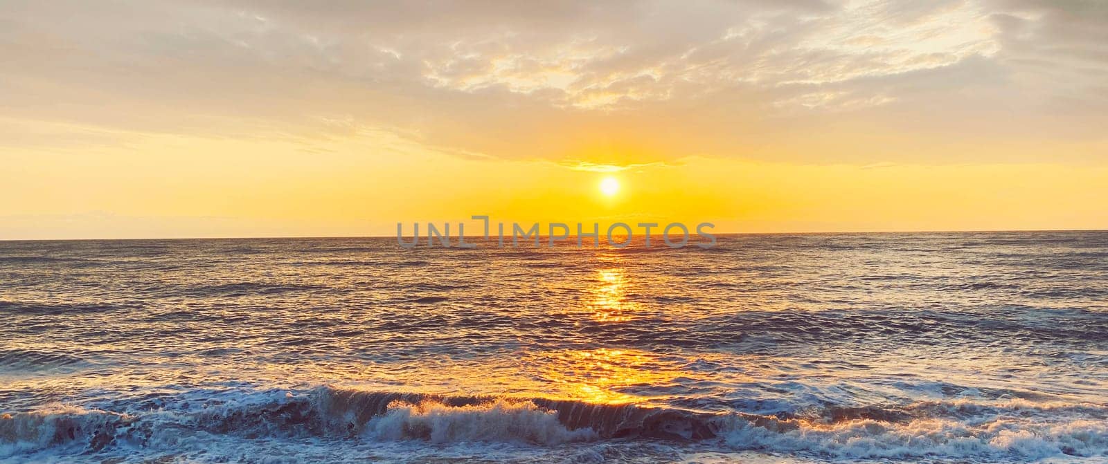 Seascape, sea landscape with waves and rocky coast at sunny sunset in the evening.
