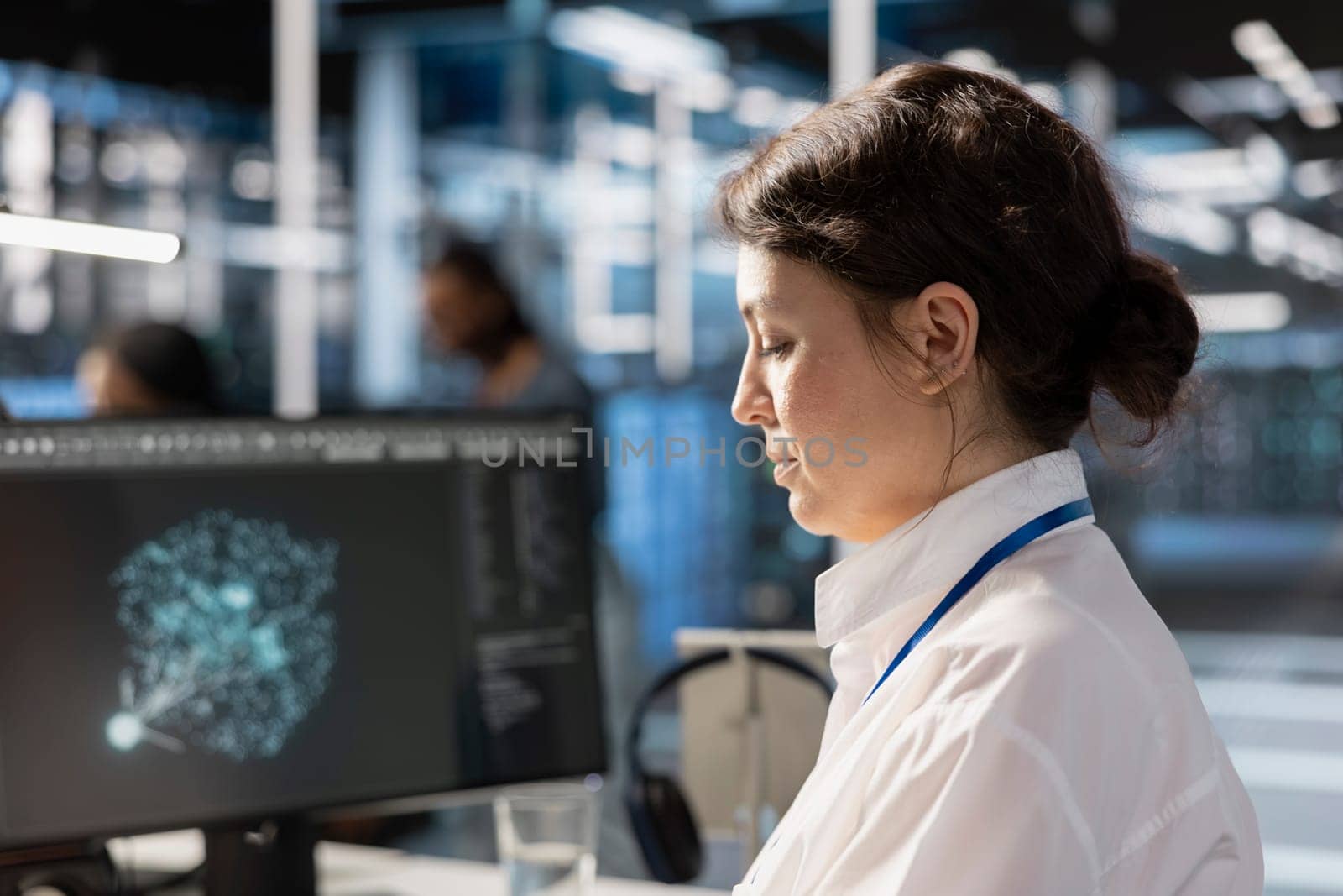 Data center computer scientist analyzing software logs metrics on PC monitor, optimizing systems. Close up of woman in server farm inspecting resource utilization, managing application efficiency