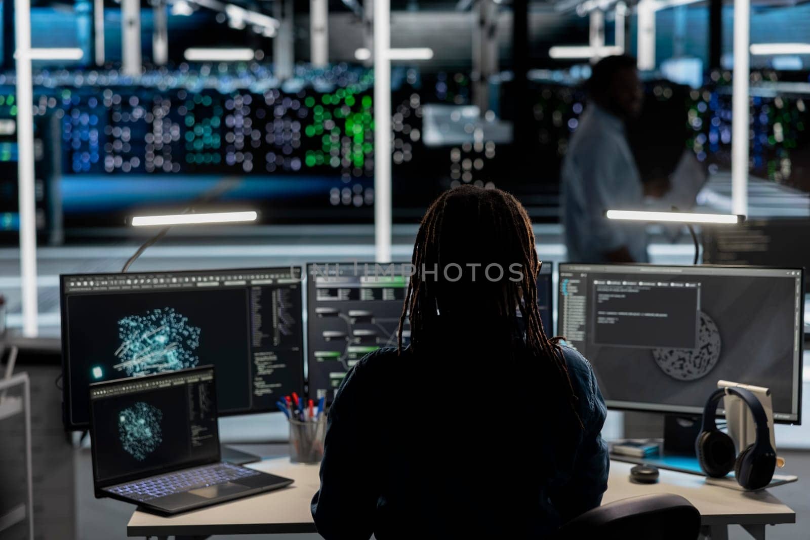 Data center software developer uses AI visualization tool to oversee automated repetitive tasks. Server room worker adapting infrastructure systems based on data analytics graphs using PC
