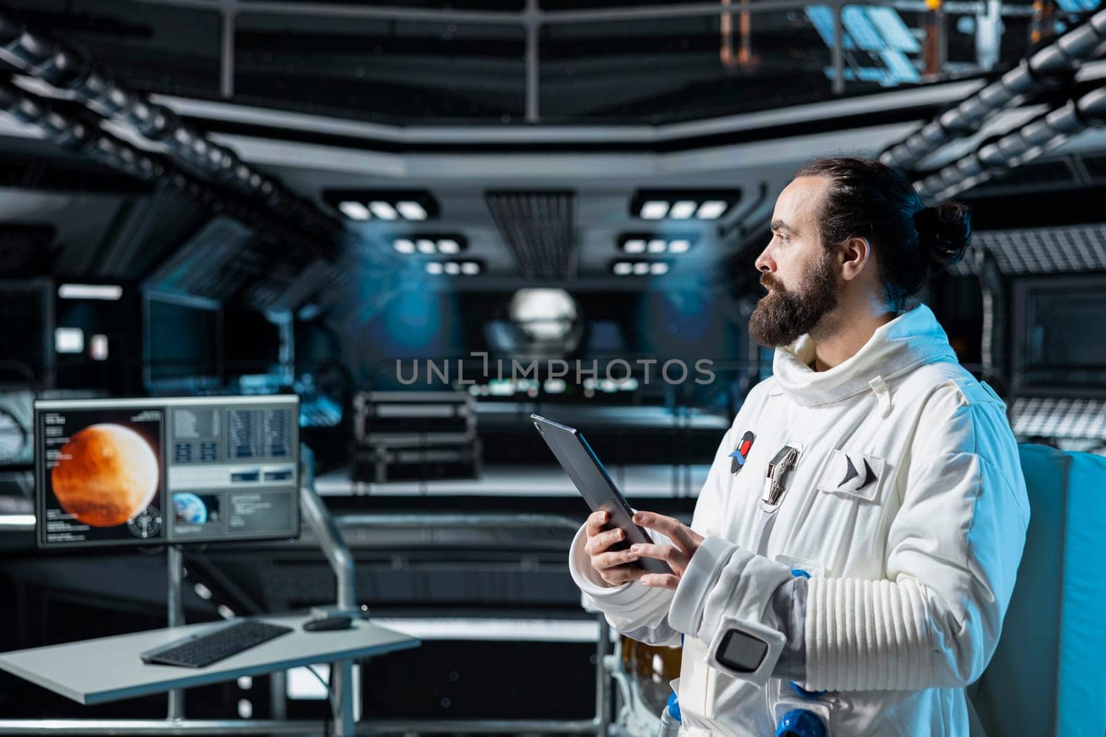 Cosmonaut in orbital station using tablet to verify navigation coordinates towards Mars. Man working on orbital station analyzing mission logs and doing Martian surface research