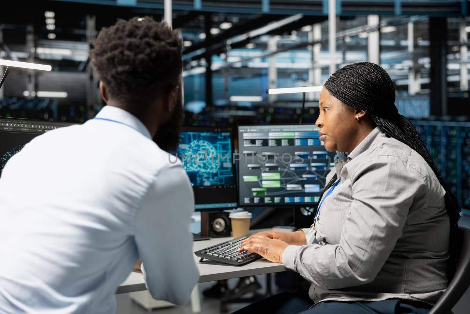 Data center engineering team using artificial intelligence neural networks technology. Professional and coworker in server room using AI programming language to configure specialized hardware