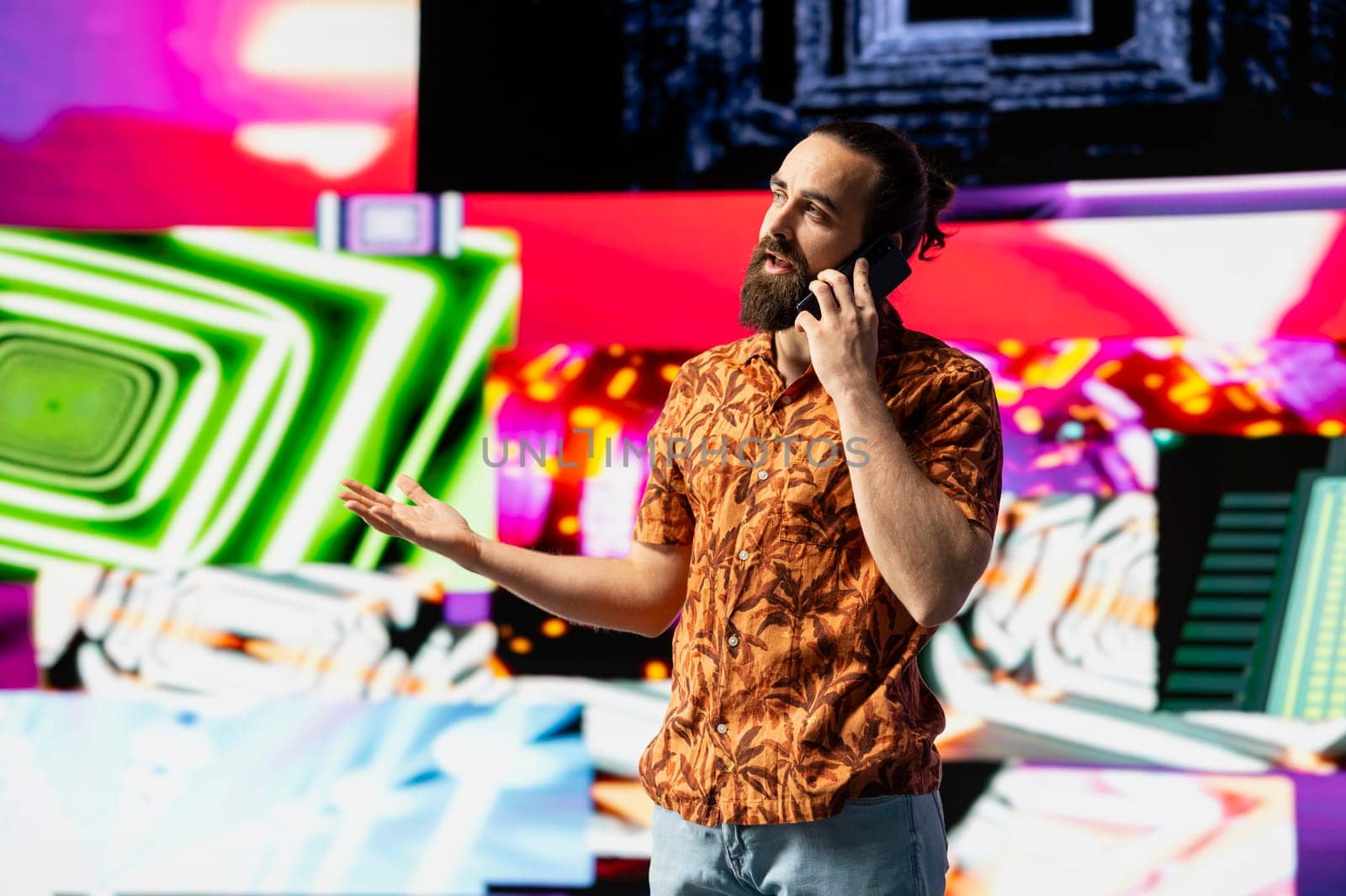 Stylish vlogger and DJ answers a phone call under vibrant neon lights, nightlife vibe with music culture, visuals and urban ambiance for social media or digital streaming. Cool creative guy.