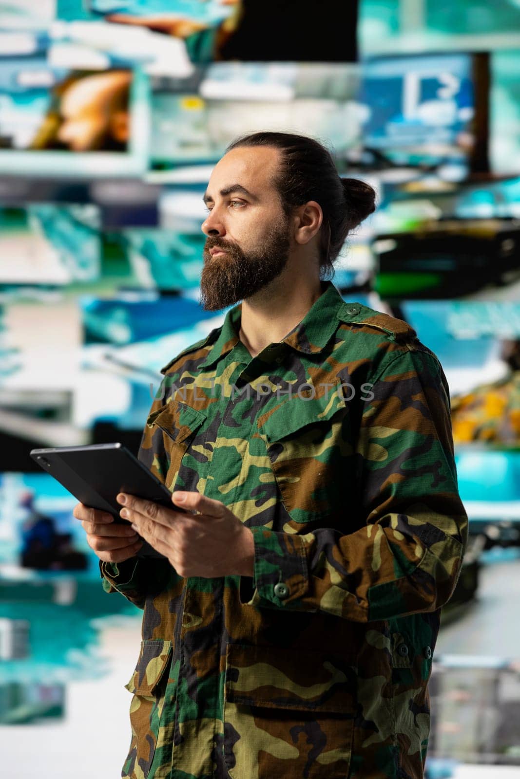 Young veteran reviewing battlefield data in a high tech command center, ensuring war planning through tactics and geopolitics details. Modern military environment focused on protection.