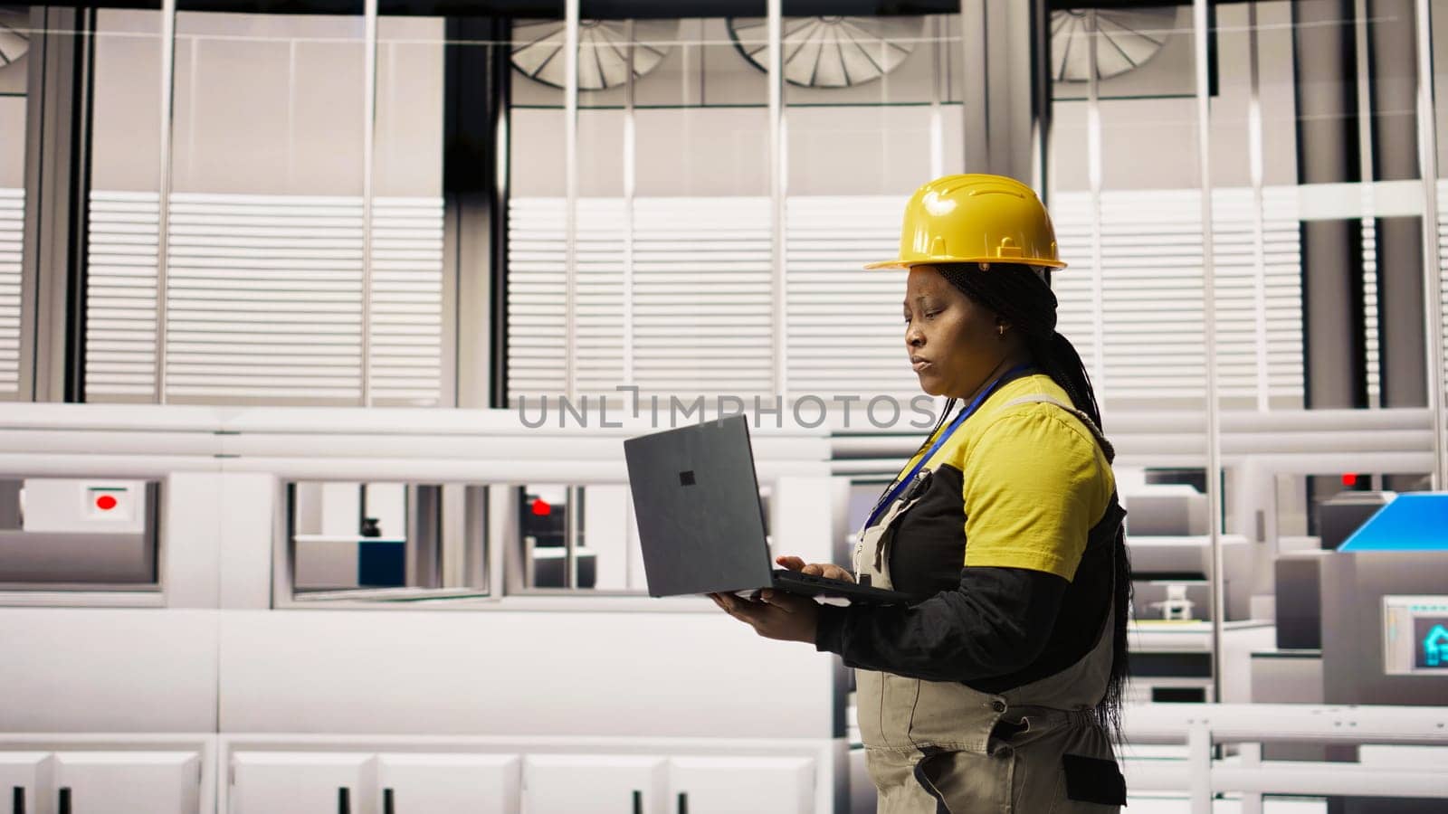 Specialist using laptop to conduct routine inspections in industry 4.0 plant producing renewable energy. Technician in photovoltaics smart factory testing equipment using notebook, camera A