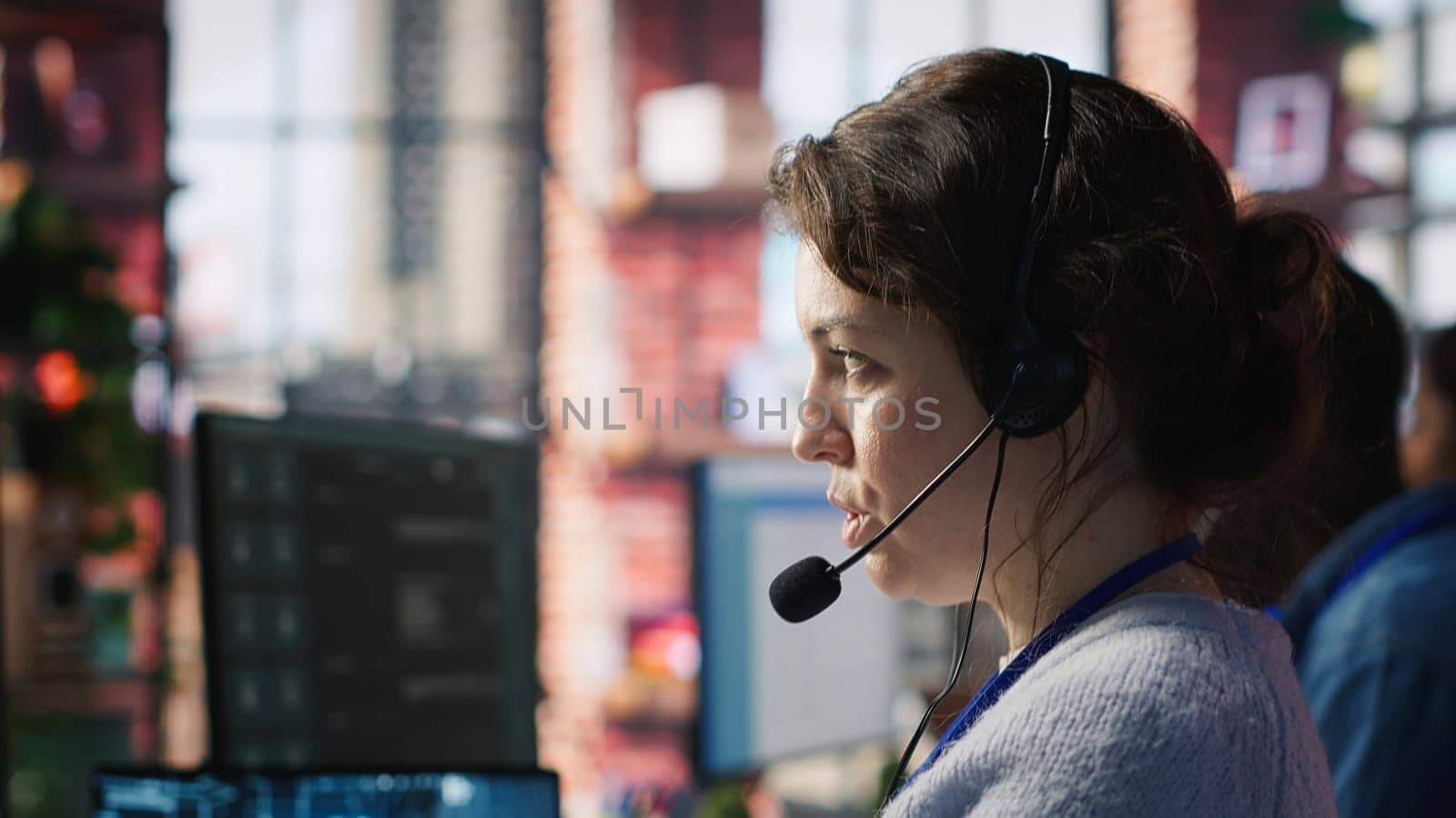 Call center agent uses artificial intelligence to enhance customer interactions and resolve inquiries efficiently. Woman in customer service office using AI communication technologies, camera A
