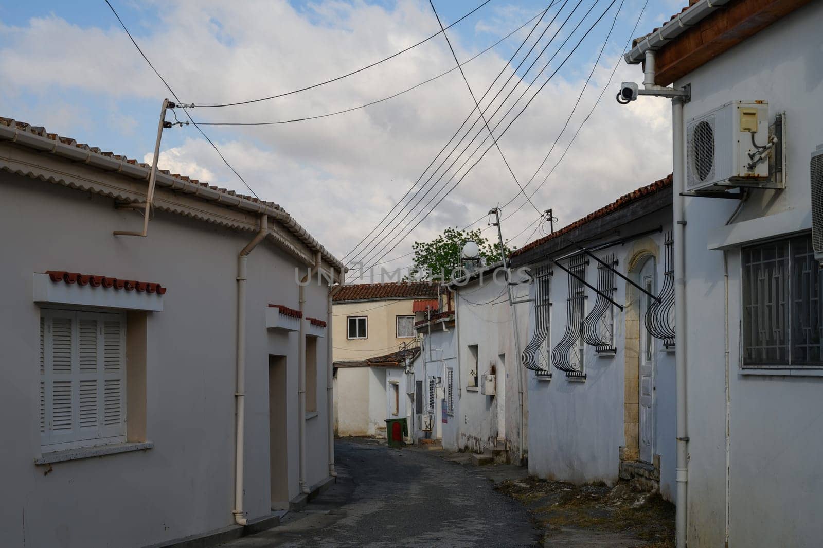 Traditional narrow street in Lefke, Cyprus, lined with whitewashed walls and showcasing authentic Mediterranean village charm.