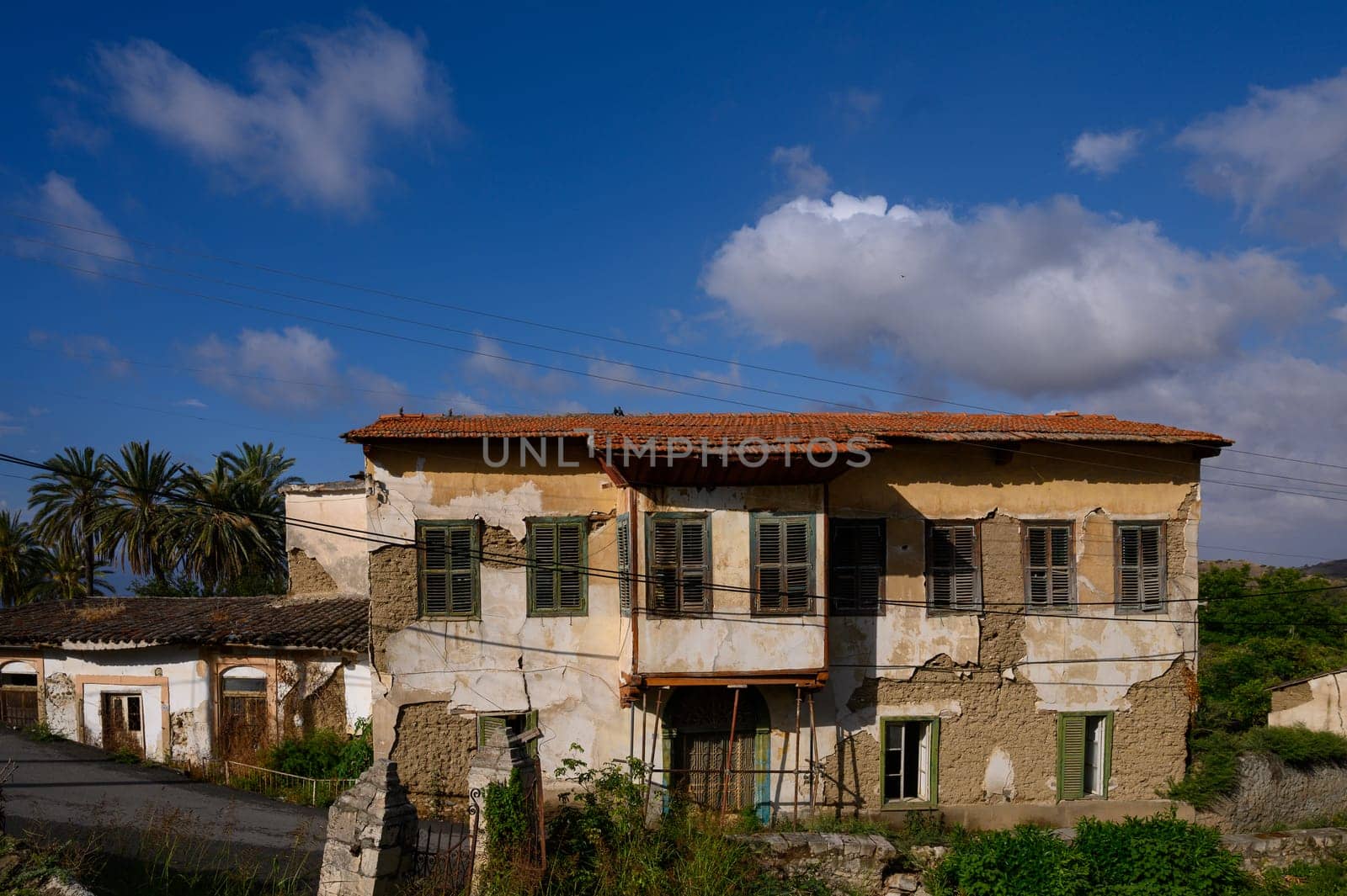Quiet narrow street in Lefke, Cyprus, with white walls, arched doors, and rustic charm.