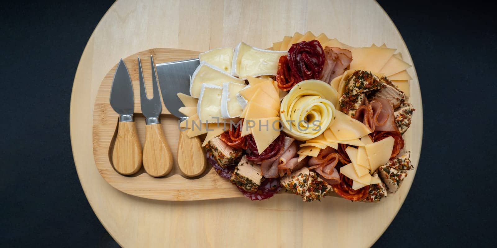 Cheese and meat charcuterie board. Gift present idea, dinner lunch plate. Minimal effort visually pleasing snacks. Simple meal preparation with special cheese knives. Wooden board