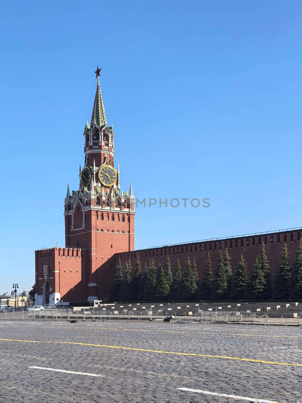 Moscow, Russia - May 28, 2025. Majestic view of the Spasskaya Tower. The iconic red brick tower and its clock under a bright blue sky, symbolizing historical architecture. Made on smartphone.