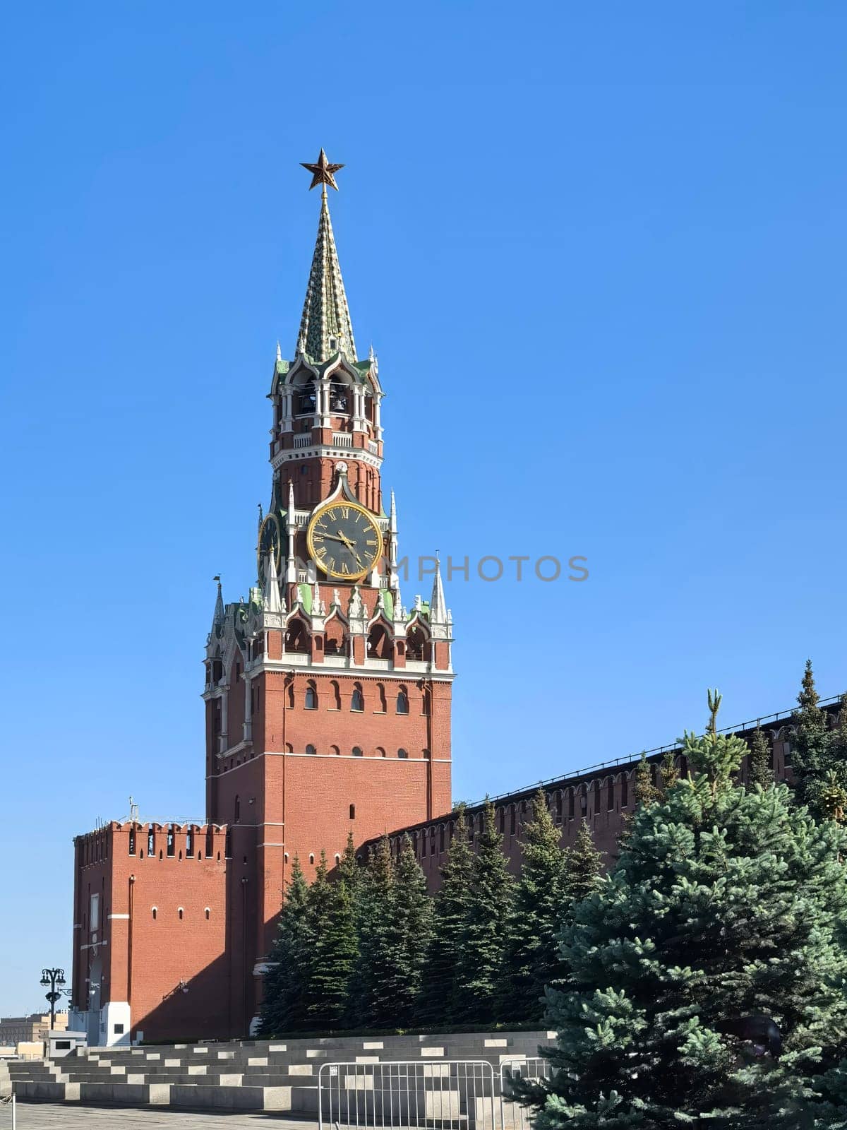 Moscow, Russia - May 28, 2025. Spasskaya Tower stands majestically against a clear blue sky, showcasing its historical architecture and iconic clock face in the Moscow Kremlin. Made on smartphone.
