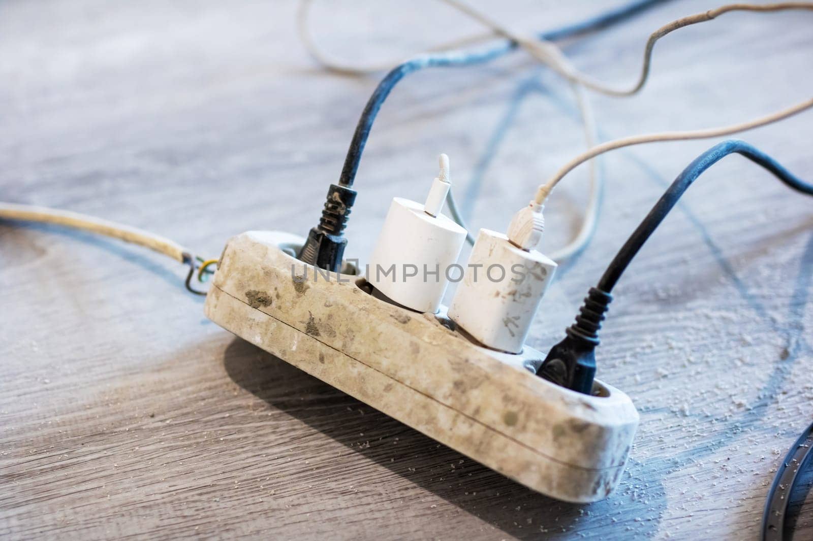 A variety of wires are connected into a power strip, providing multiple electrical outlets for various devices to utilize electrical power