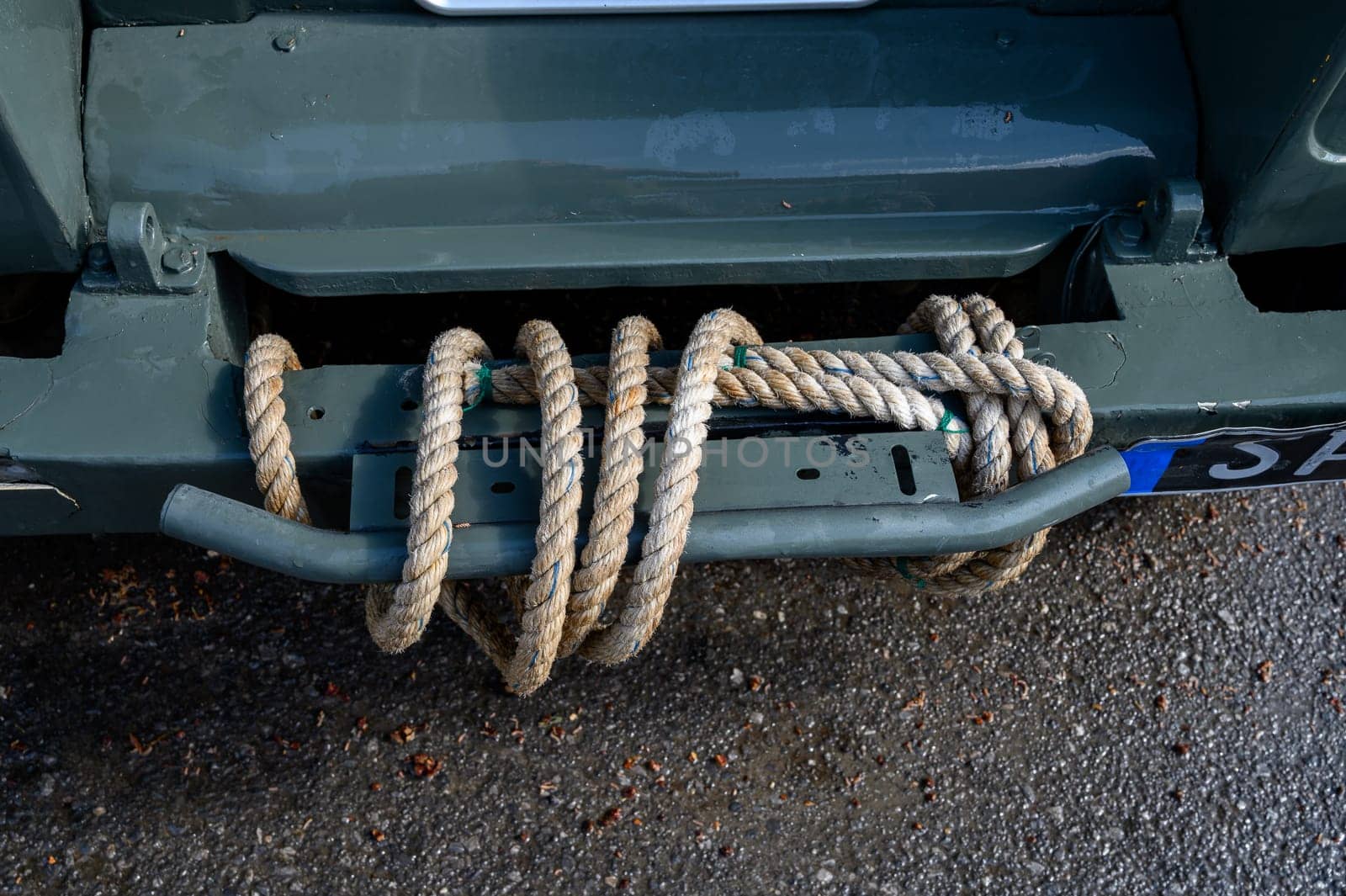 Close-up of a sturdy rope wrapped around the bumper of an off-road SUV, used for towing or recovery, photographed in Cyprus.