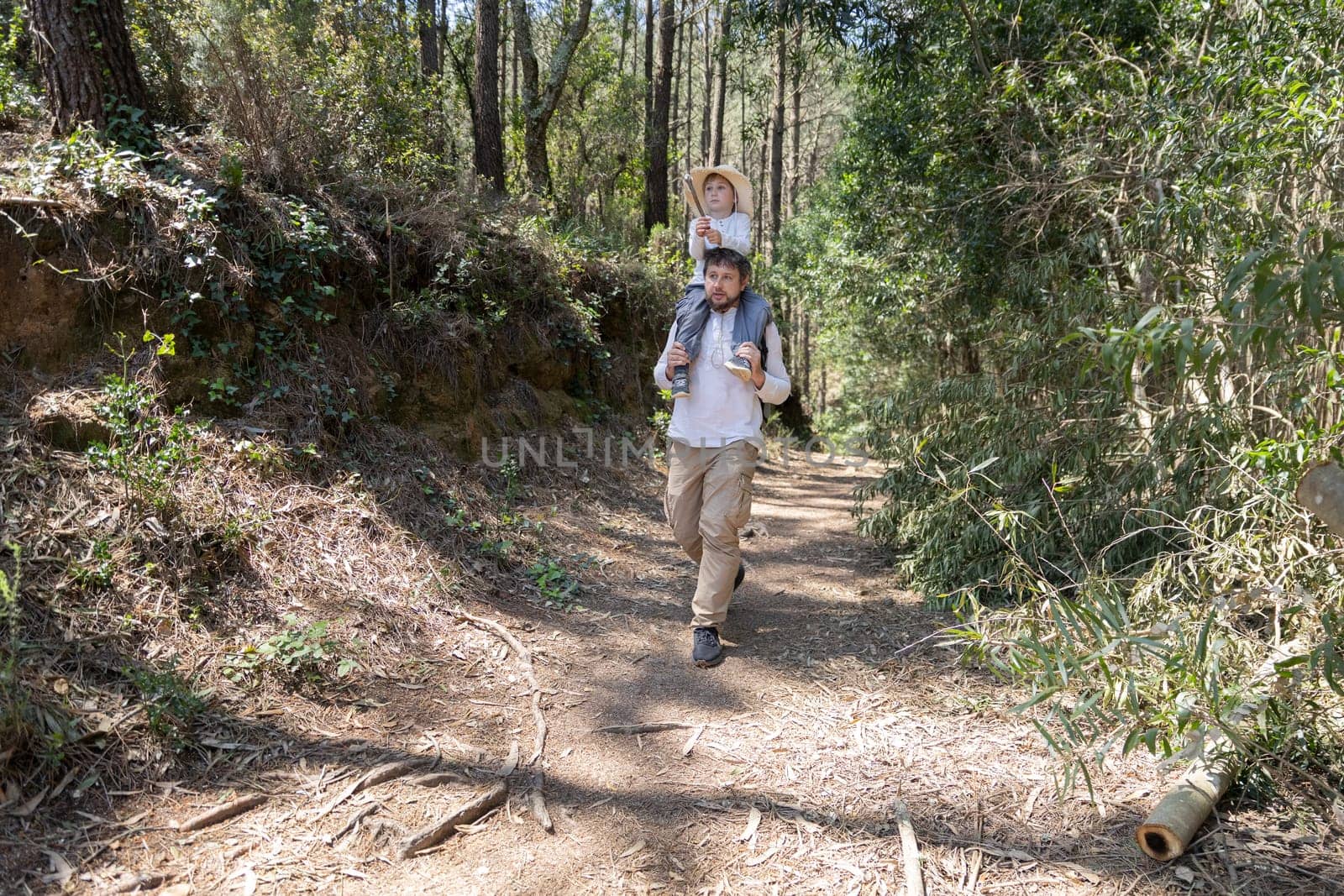 Father and son enjoying a hike in the woods, promoting family bonding and outdoor activities