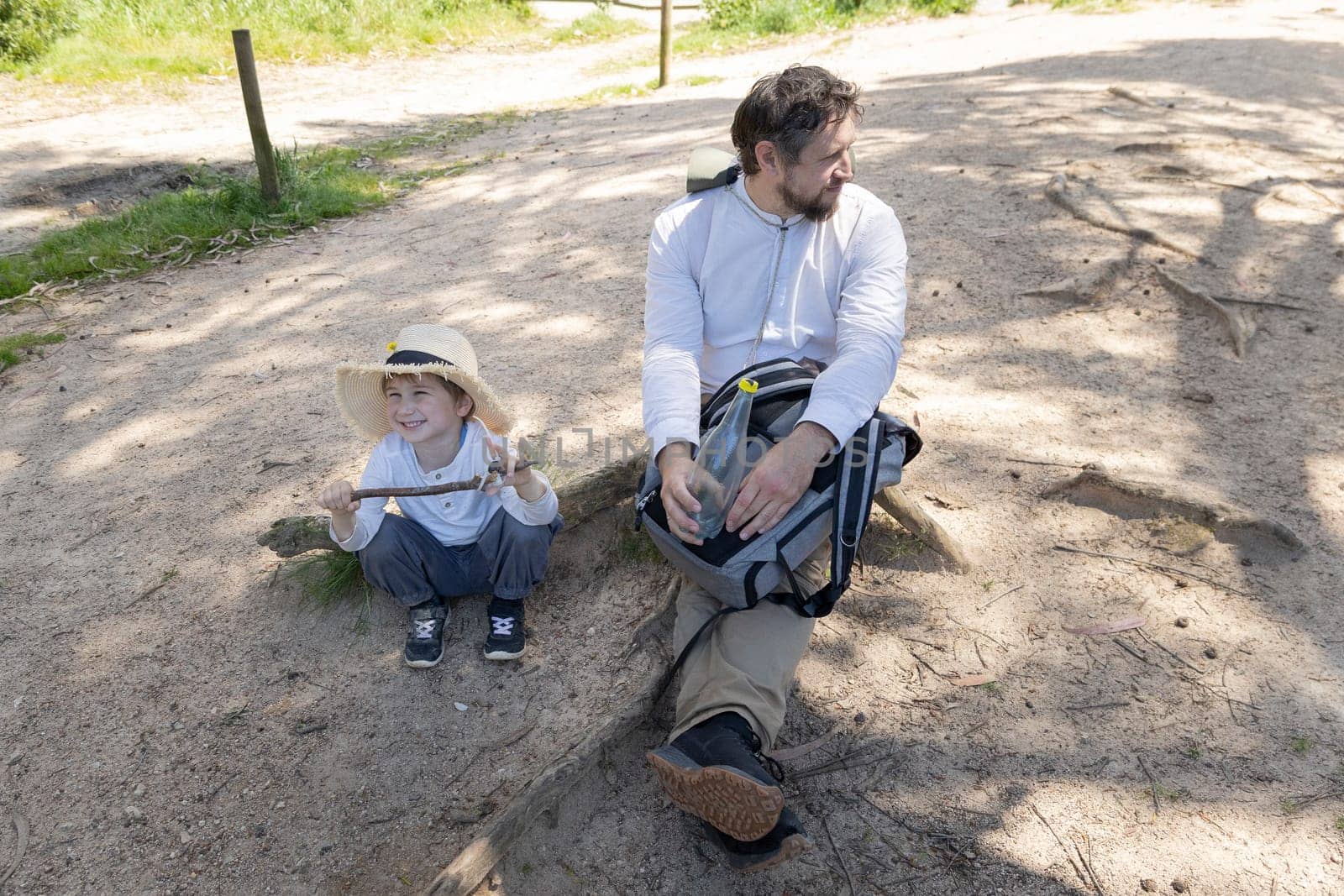 Father and son taking a break during their hike in the woods, enjoying quality time together in nature
