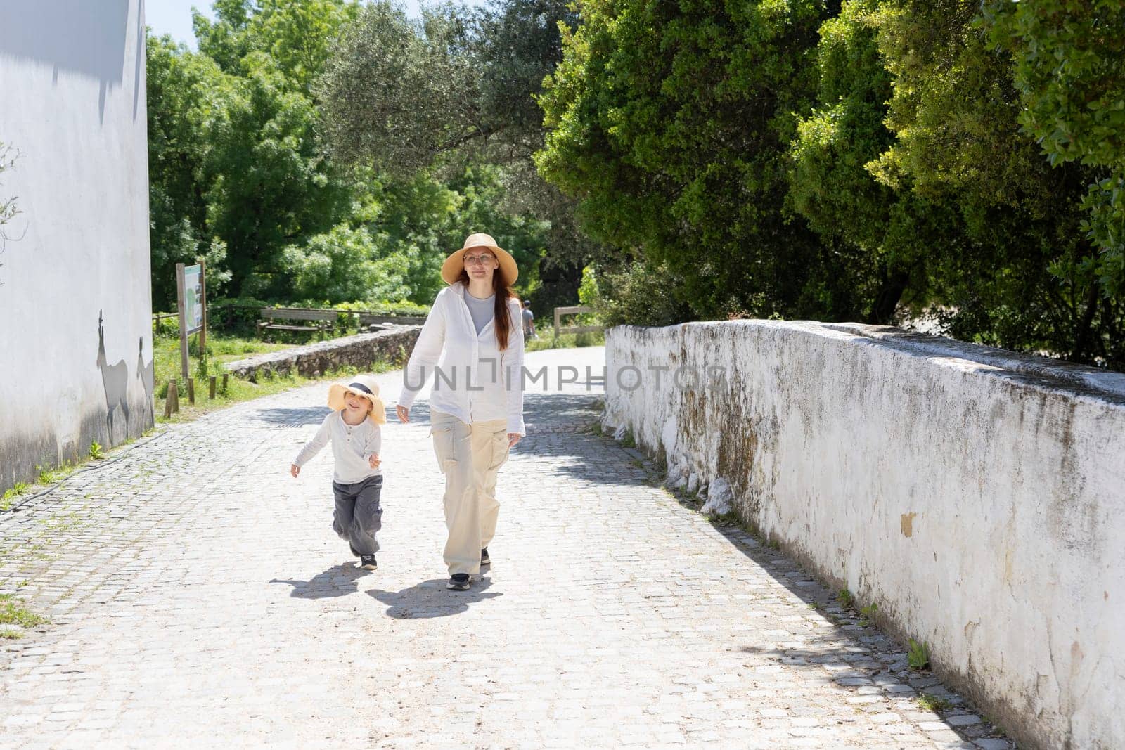 Mother and son enjoying a leisurely walk on a sunny day in the countryside
