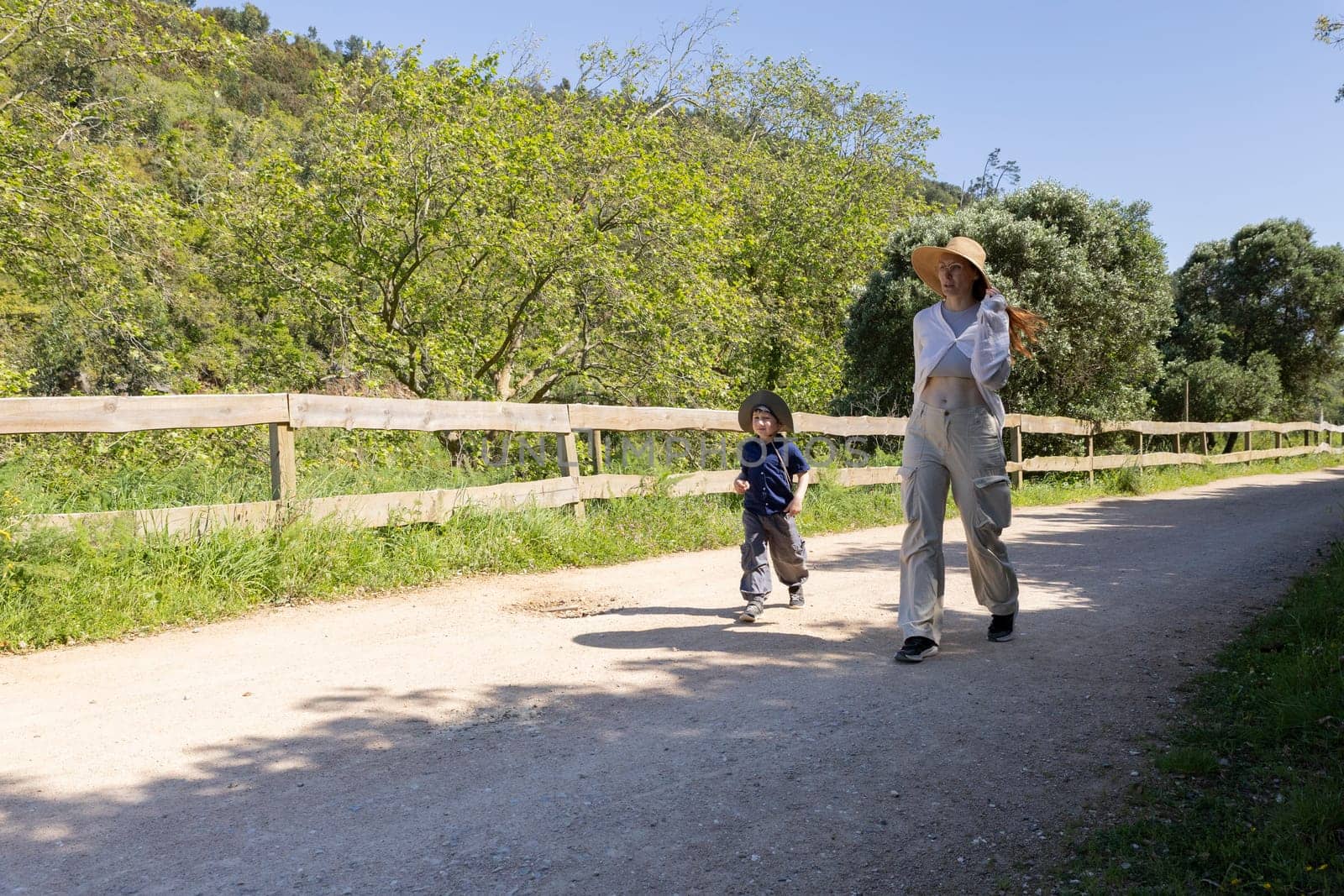 Mother and son enjoying a leisurely walk on a sunny summer day in the countryside