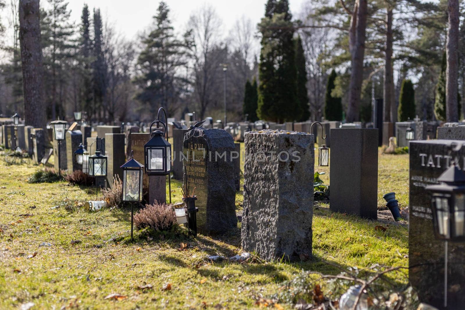 Espoo, Finland - March 27, 2025: A peaceful Lutheric cemetery in Finland, featuring a solitary grave marked by a stone cross. The surroundings are calm and reflect a quiet, respectful atmosphere