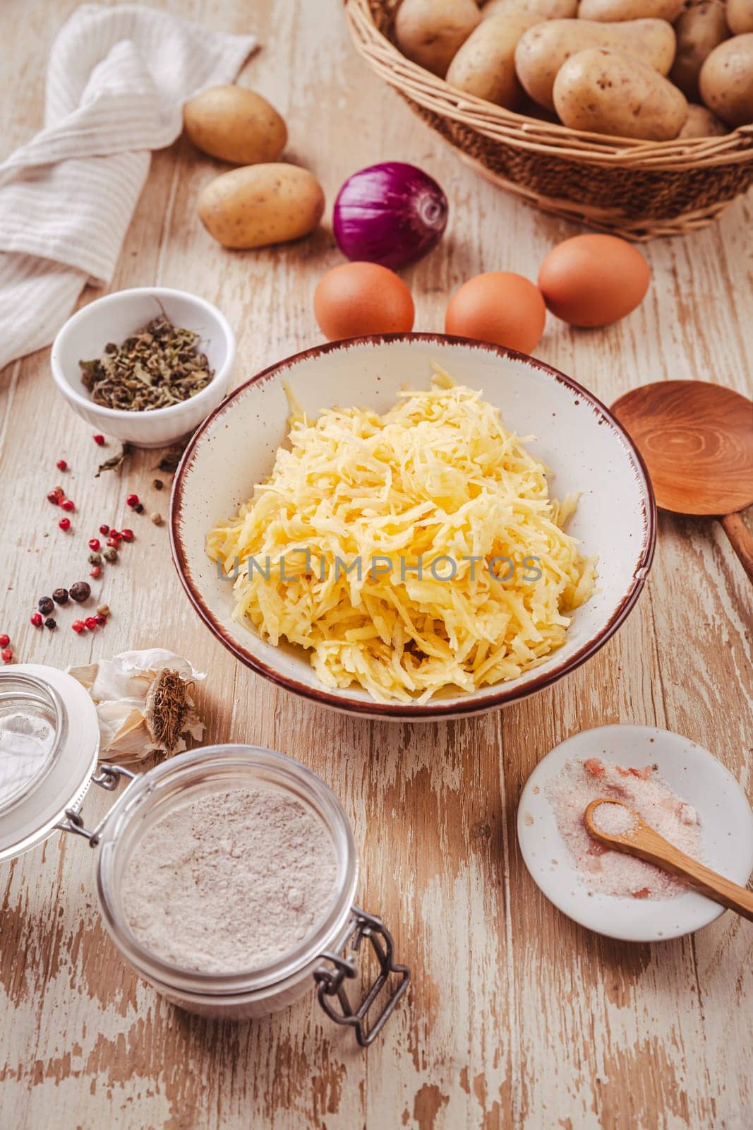 Grated raw potatoes with eggs and ingredients for  potato pancakes